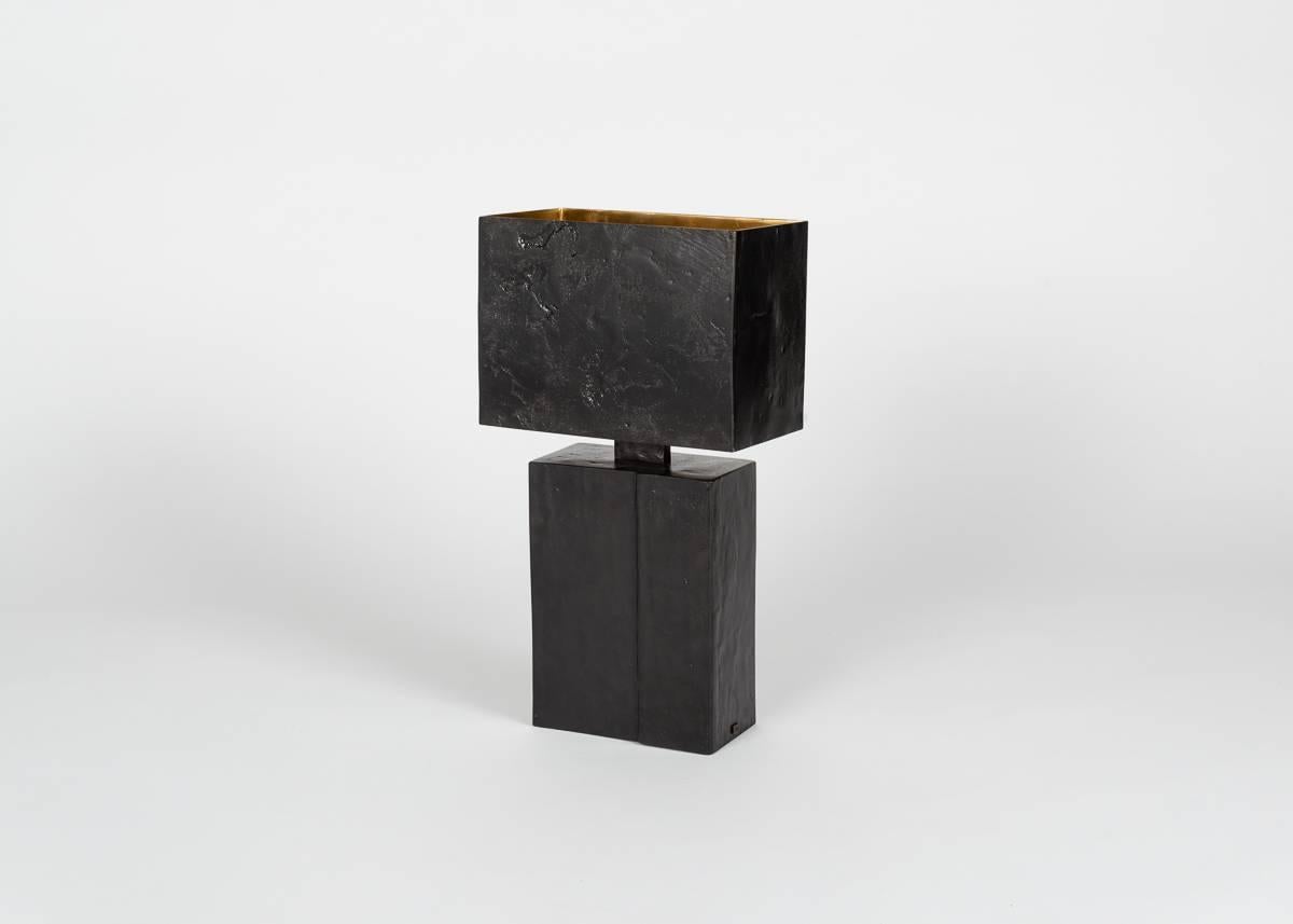 Straddling the line between the subtle and the sturdy, this tactile all-bronze table lamp with its sculptural base and discretely patterned shade is masculine and powerful, yet not overbearing. A quiet statement as suited to the office as it is to