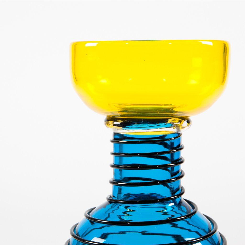 The Alioth Glass Vase was designed by Ettore Sottsass for Memphis in 1983. The Venetian glass vase features blue fusions and black threads. Signed on the base.

Ettore Sottsass was born in Innsbruck in 1917. In 1939 he graduated in architecture at