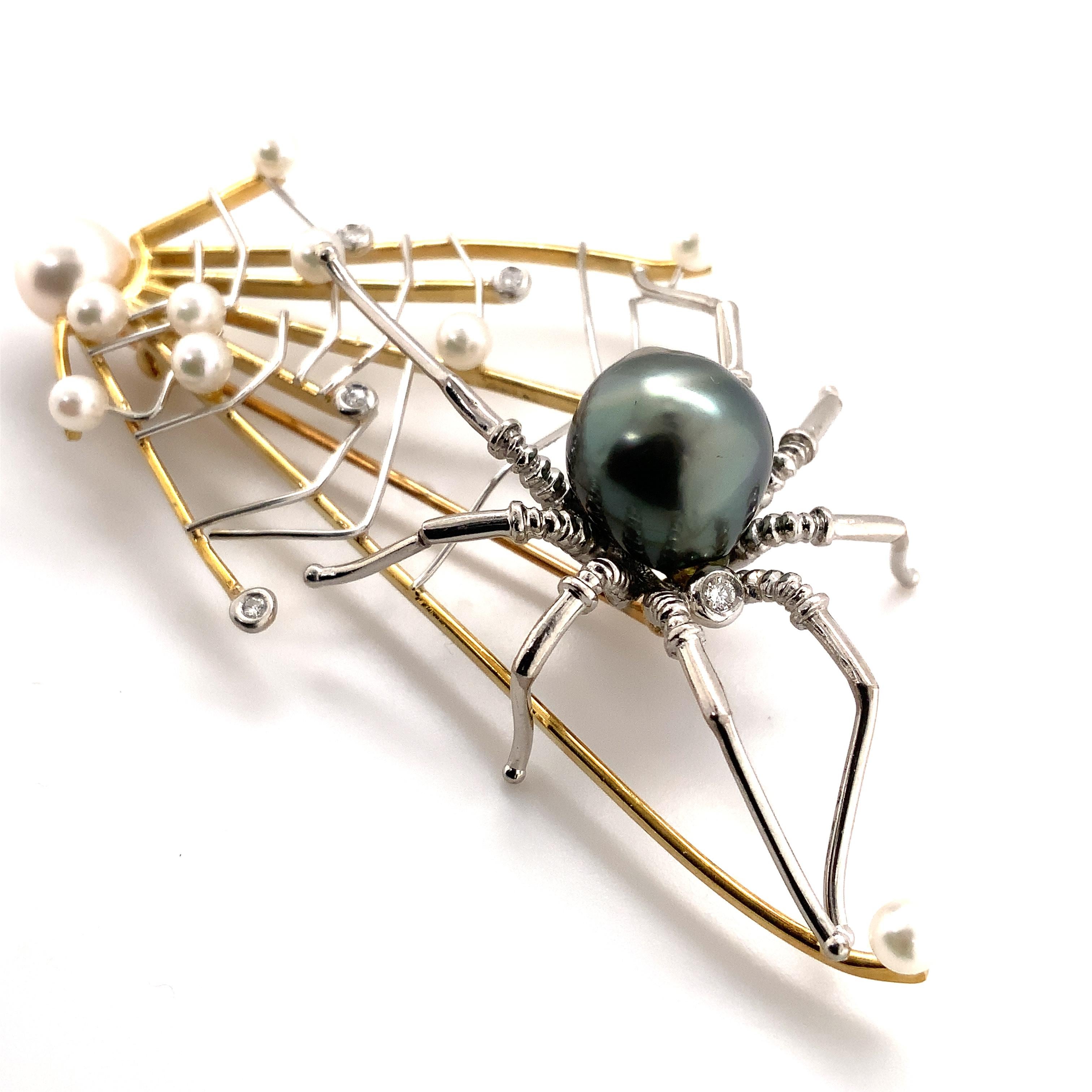 Alishan Limited edition Platinum and 18kt Gold Spider and the Web Pearl and Diamond Pendant / Pin. This Whimsical Design contains 10 White Akoya Pearls, One 11 mm Black Tahitian Pearl, and 6 Bezel set Diamonds.
6 = 0.18cts t.w. Brilliant Cut Round G