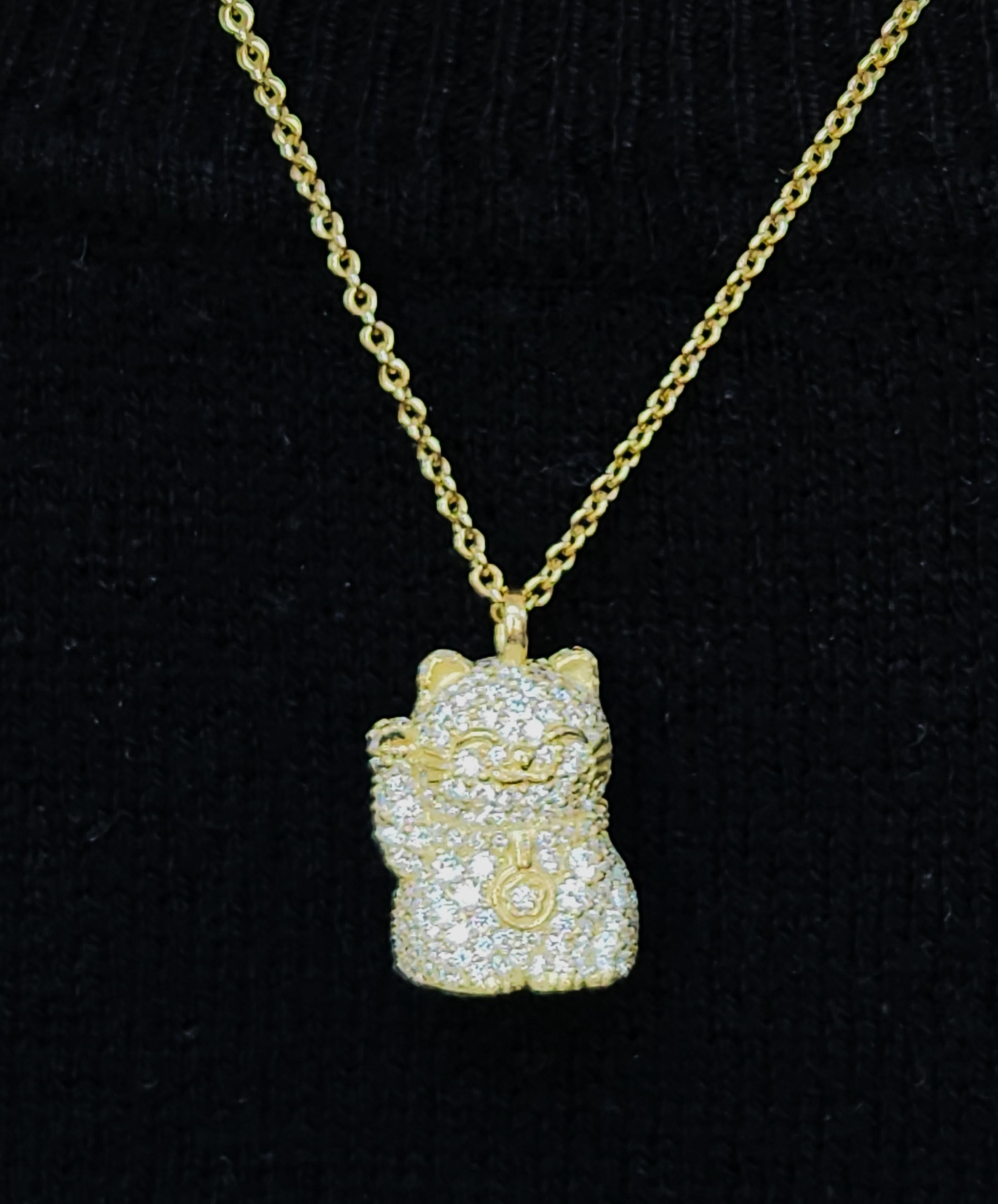 A totally blinged out full pave diamond Hope Cat with Peace sign Necklace in 18K green gold. Get noticed with this sparkling diamond encrusted 3D Hope Cat (Maneki Neko) 2.50CTTW diamonds. The Japanese iconic welcoming cat is interpreted by Alison to