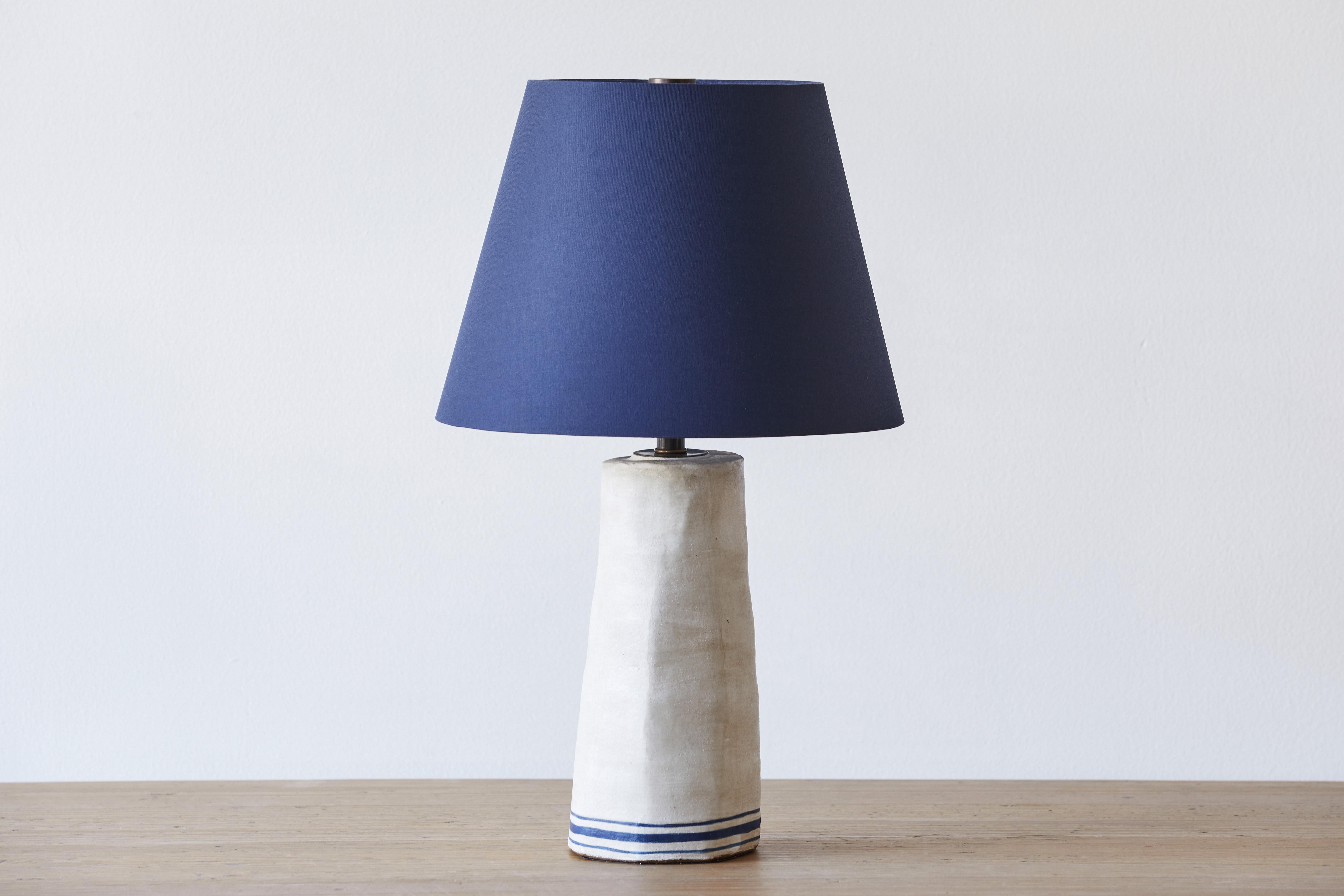 Alix Soubiran Palo table lamp with a custom Navy Bookcloth Shade.

Handmade ceramic lamp bases by the French American artist Alix Soubiran. The lamps come with brown twist cord.