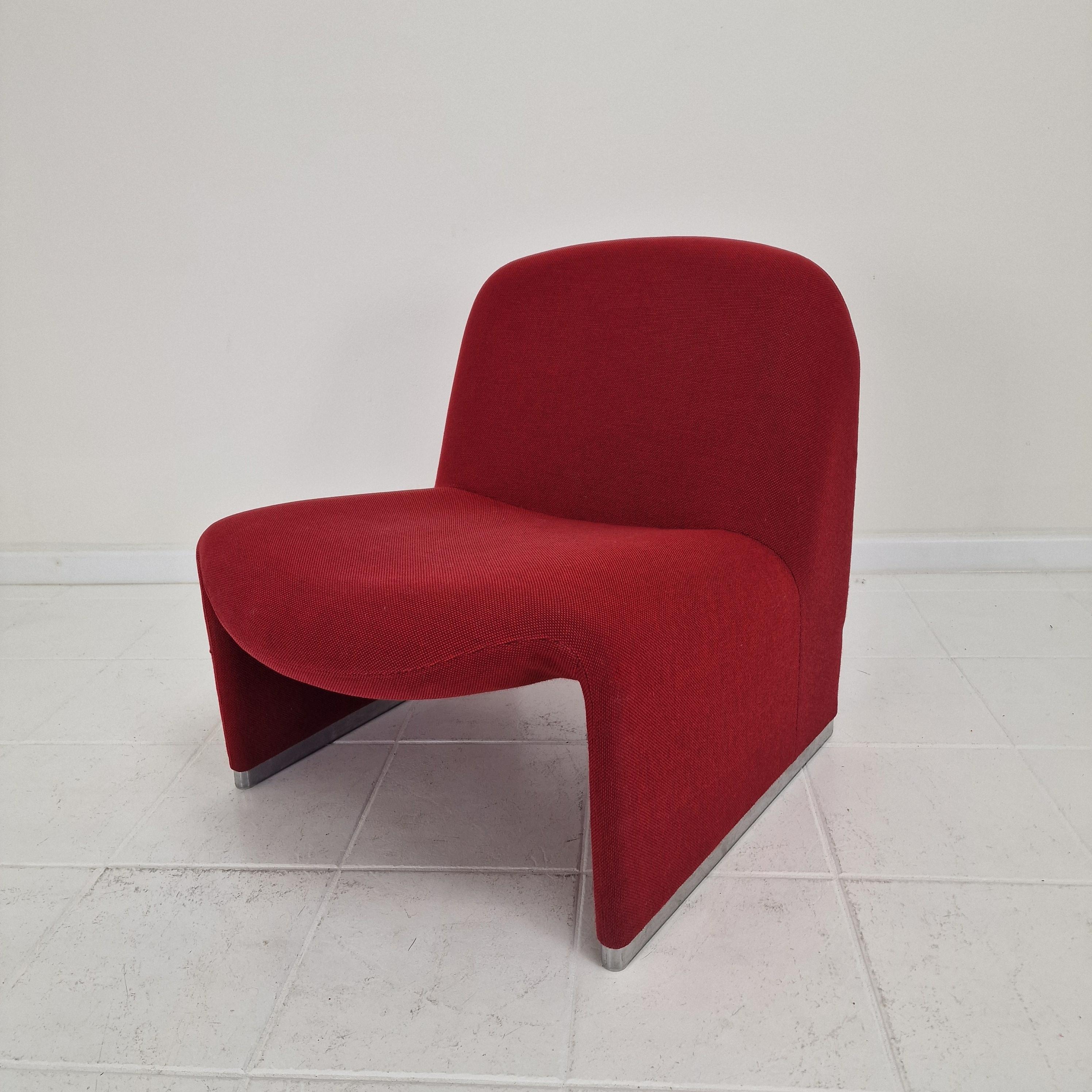 This original Alky lounge chair, designed by Giancarlo Piretti for Artifort in the 1970s, is a true design classic. The chair retains its original red-orange fabric, a vibrant and rare colorway that highlights the sculptural form of the piece.

In