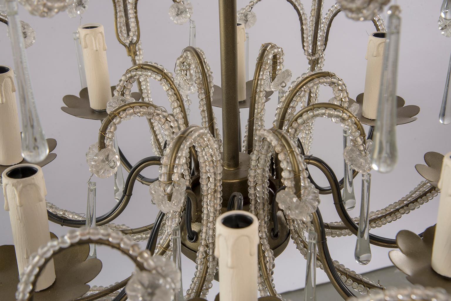 Zeitgenössischer französischer Perlenkronleuchter im traditionellen Stil. Acht kerzenförmige Lichter mit kandelabergroßen Fassungen, goldfarbener, korbförmiger Rahmen, der mit klaren Kristallperlen bedeckt und mit Kristallspitzen akzentuiert ist.