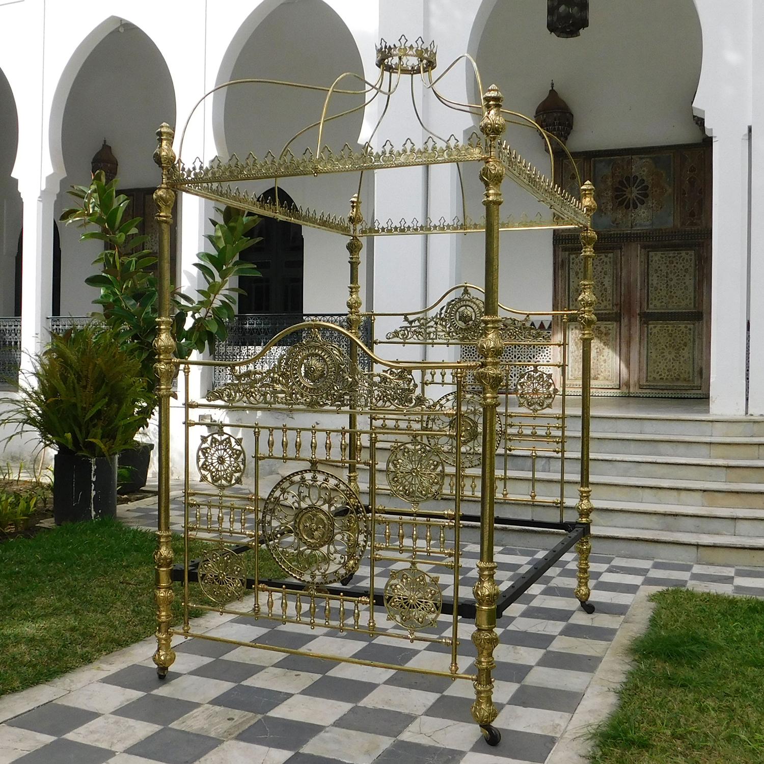 A majestic all brass four poster bed bedstead with crown and canopy. Detailed etched brass posts, displaying ornate brass fittings, support an impressive canopy, with decorative fretwork castings, surmounted by a brass crown. The two superbly