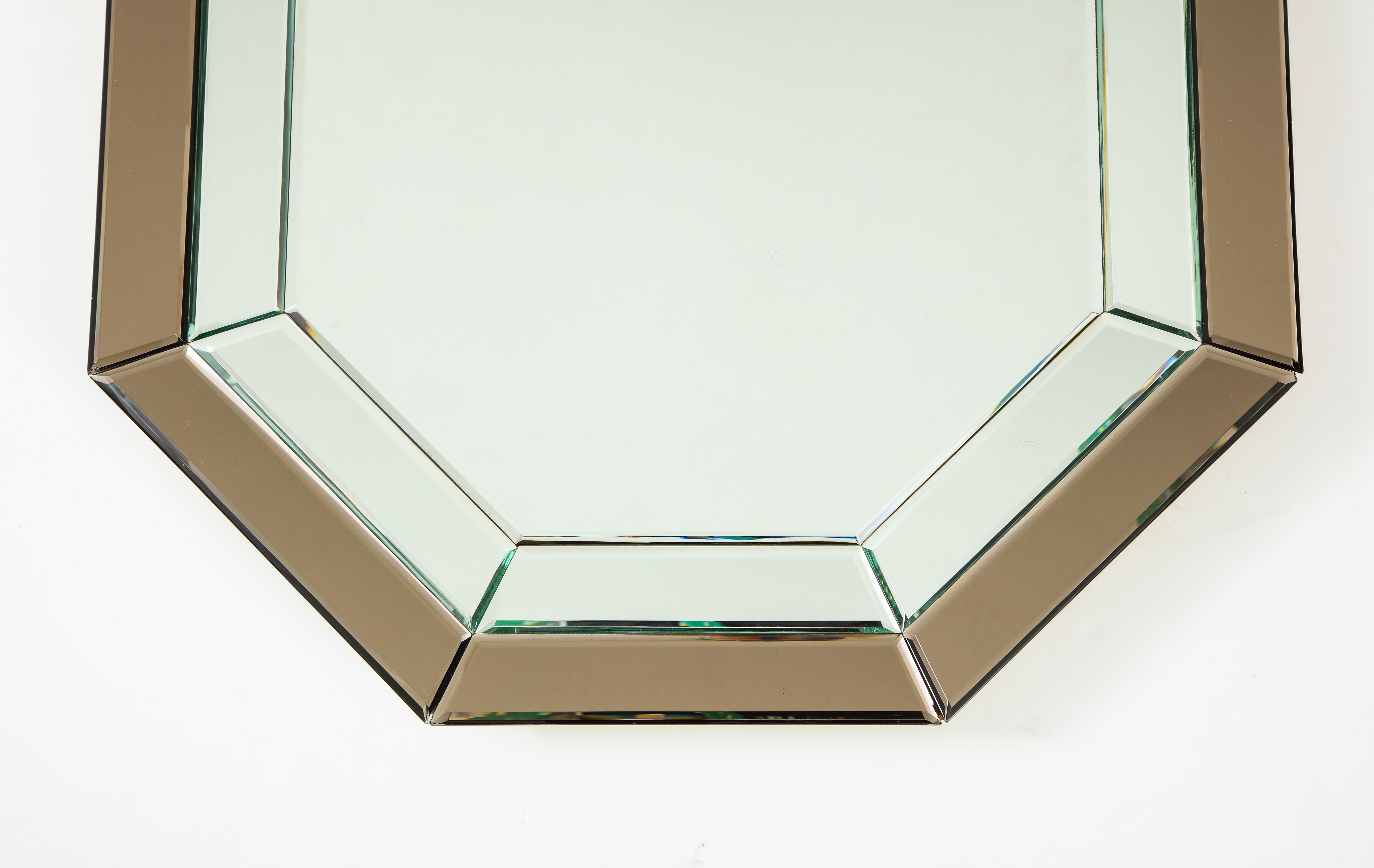 An all-glass Italian octagonal mirror frame with clear and bronze colored glass on the outer segments. 
Italy, circa 1970 
Size: 33 3/4