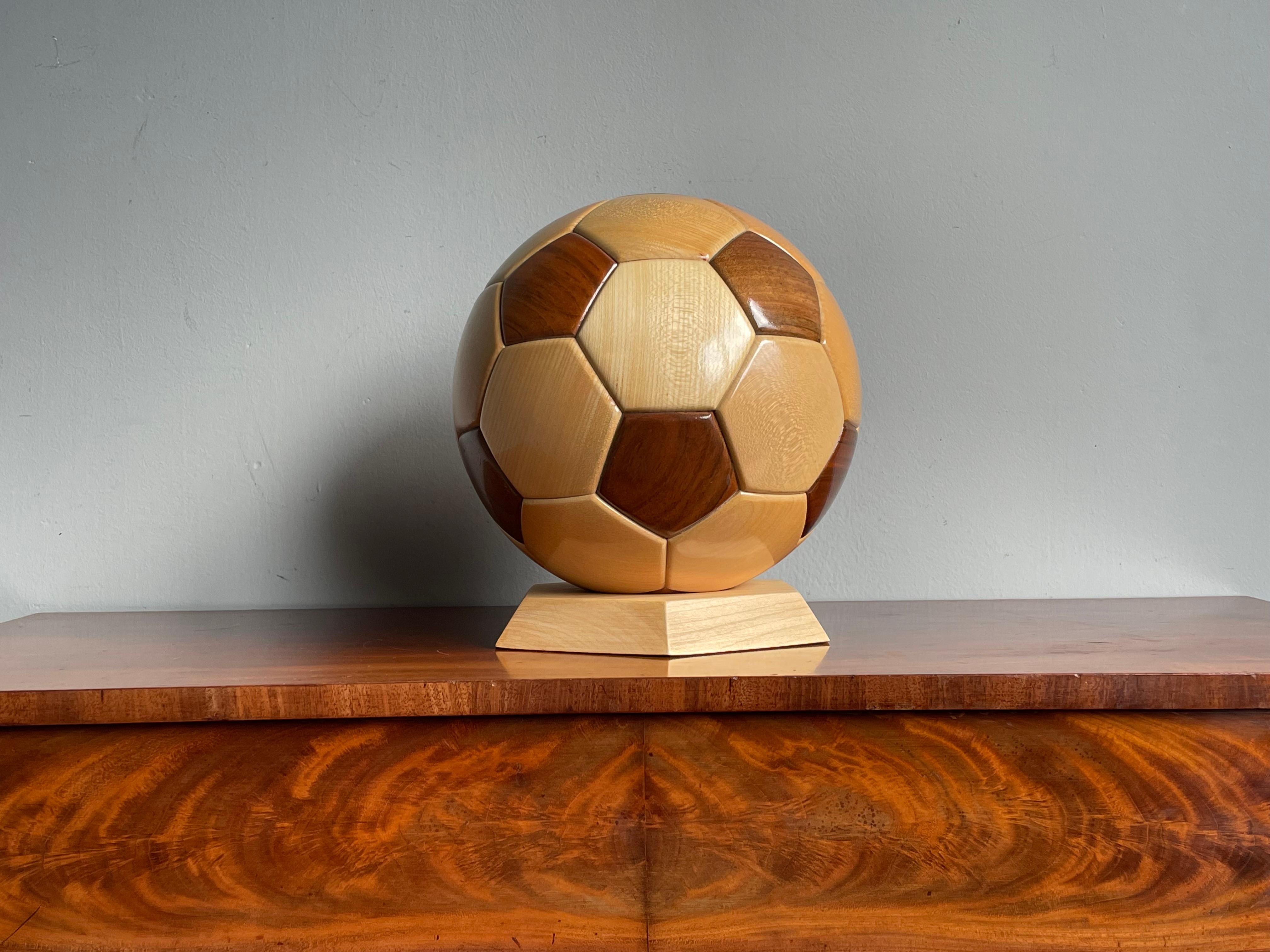 Handcrafted and perfectly realistic wooden soccer ball on hexagonal base.

This rare and beautifully made soccer ball is in near-mint condition and it is made in almost the same size as the ones with which they play in pro soccer. This stunning ball