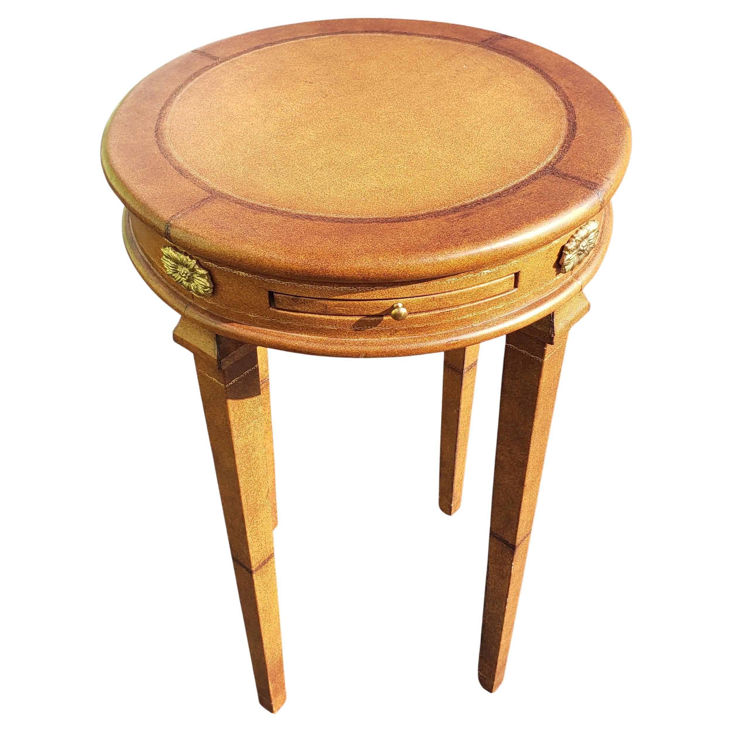 A modern, all leather wrapped and brass mounted Gueridon side table with pull out tray in very good vintage condition. Top, sides and all legs and pull out tray fully with leather.
Measures 18 inches in diameter and stands 28.5 inches tall.