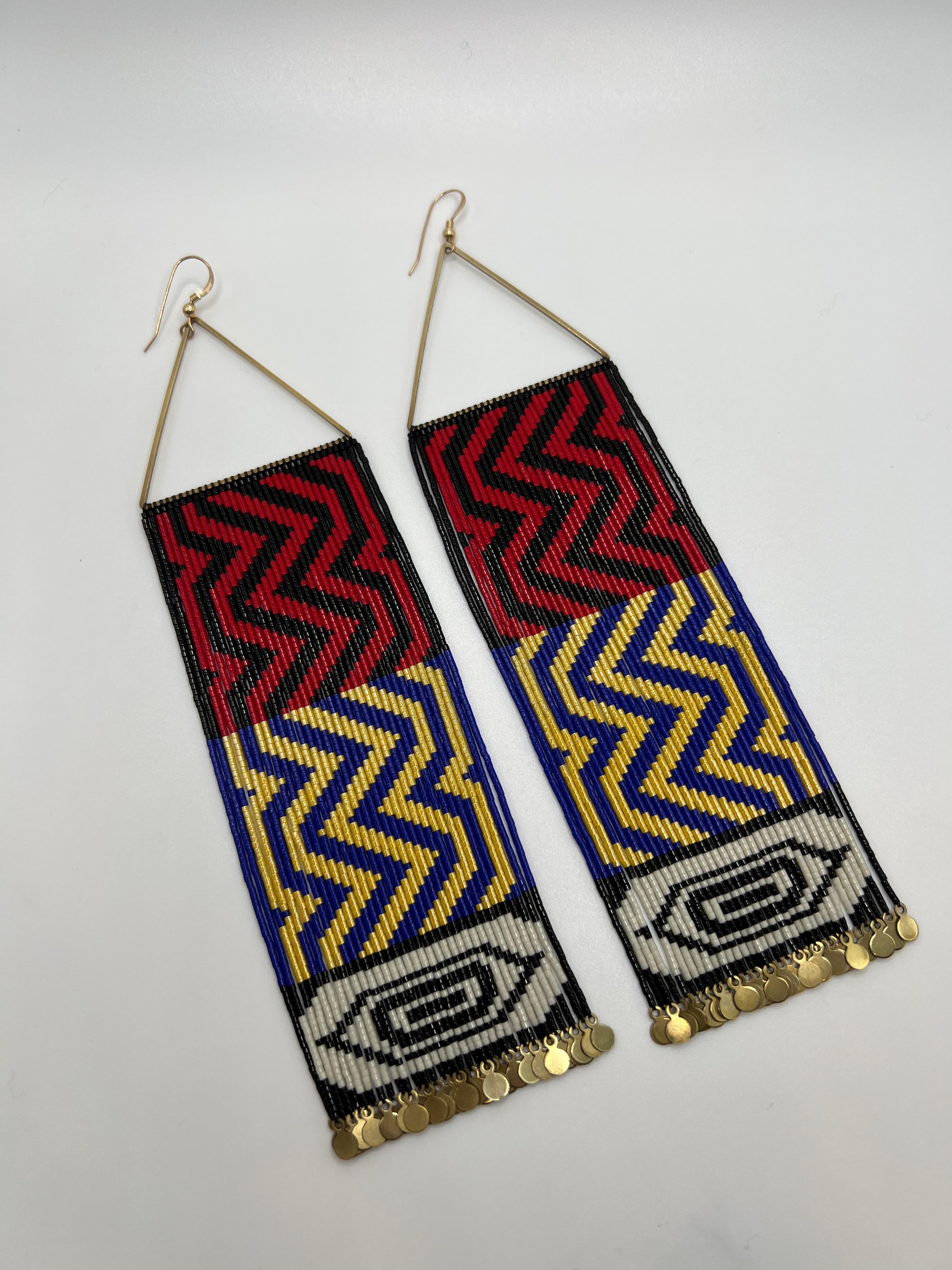These earrings are extra long, featuring the iconic ‘All my Ancestors’ Raven’s Tail design. They also have a formline eye designed in  Naaxiin style at the bottom of the fringe. Naaxiin, also known as Chilkat weaving is a complex textile that