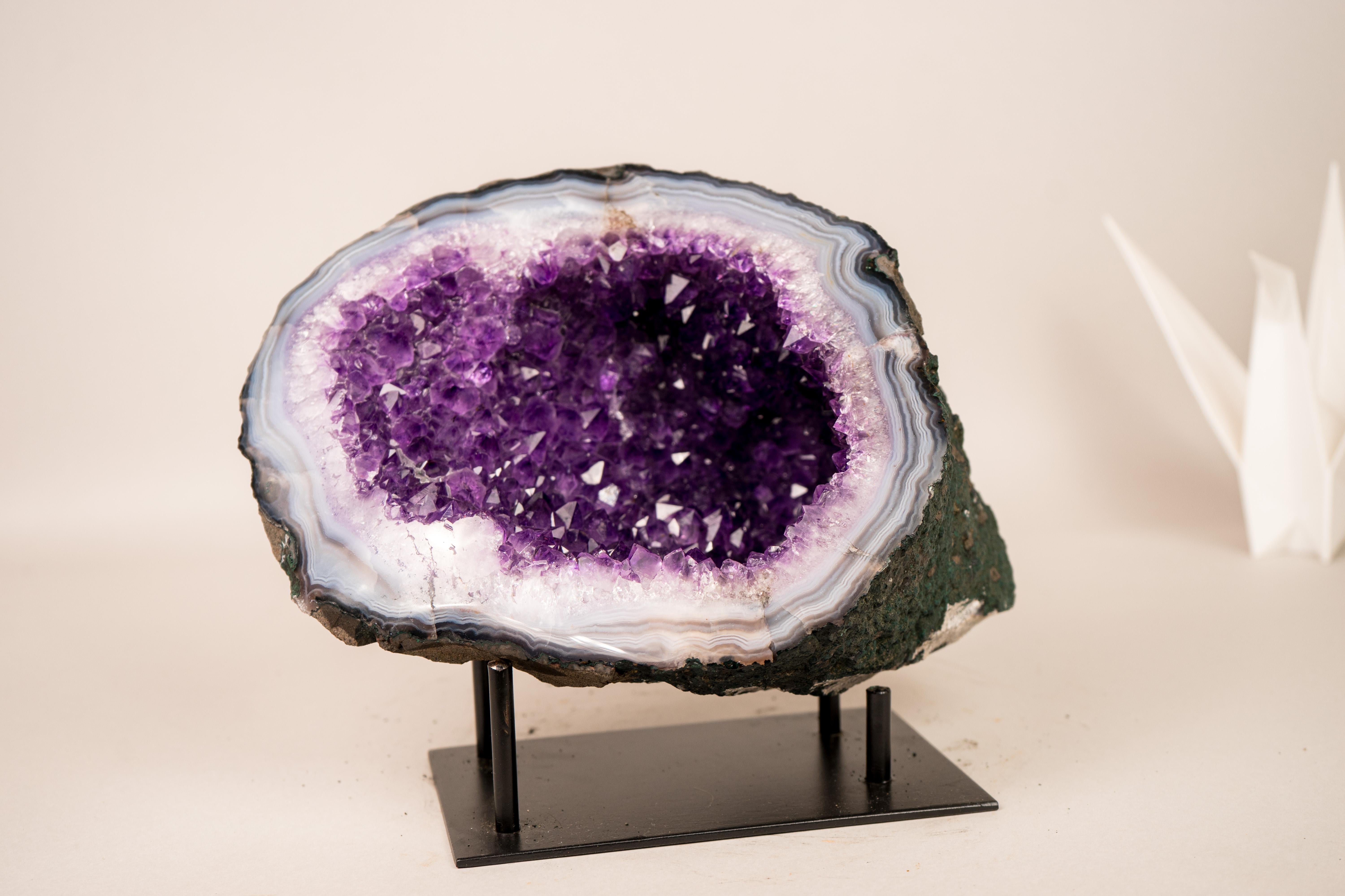 Small Amethyst on Agate Geode Cave with Blue Banded Sparkly Amethyst Druzy

▫️ Description

Small in size and bringing rare elements, this all-natural Amethyst on Agate Geode showcases numerous beautiful characteristics that transform it into a true