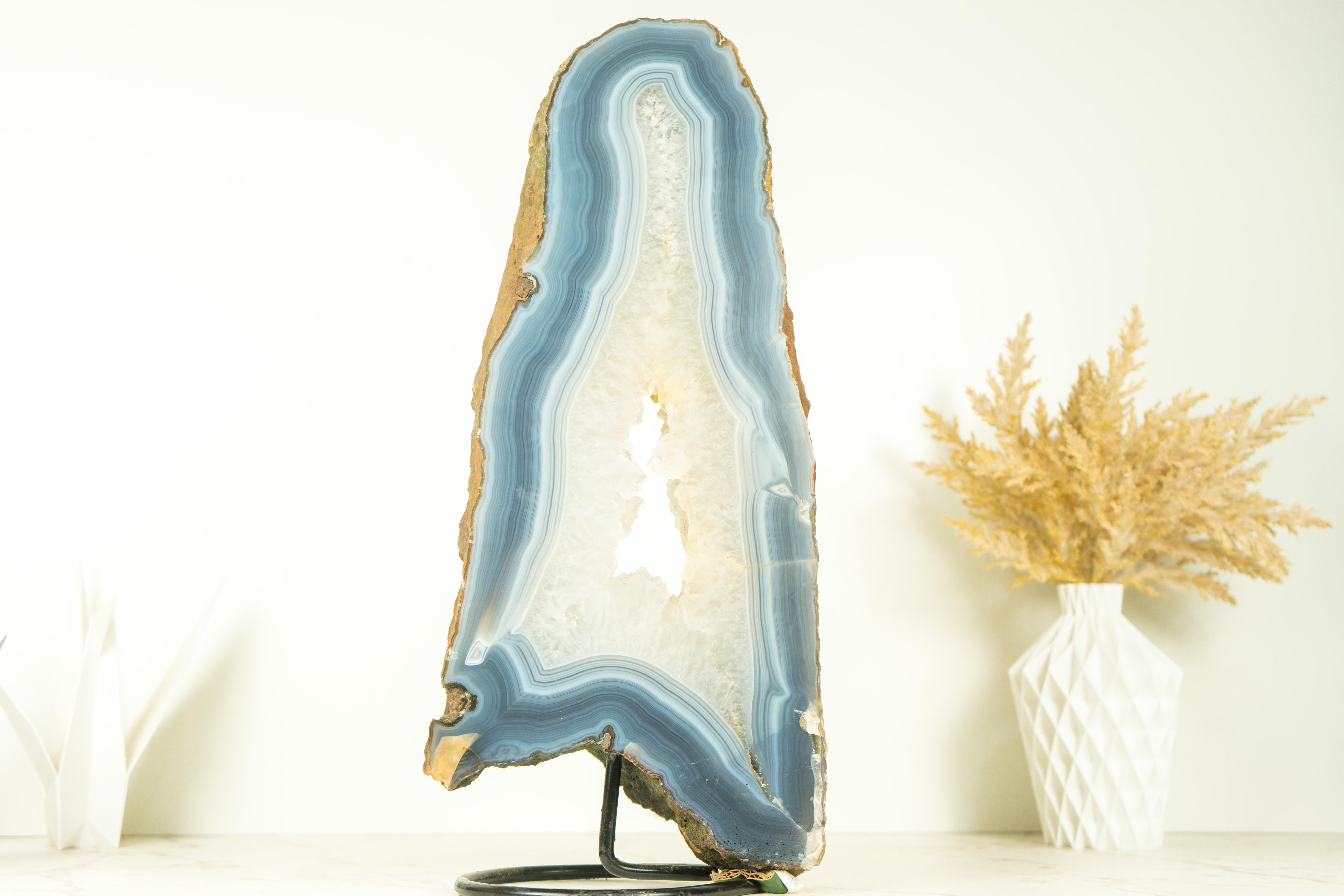 Showcasing rare formation of blue and white lace agate in a gorgeous tall format, this Agate Geode Slice is a natural artwork that will surely enhance your decor as a centerpiece, a large bookshelf accent, or a powerful tool in your healing arsenal