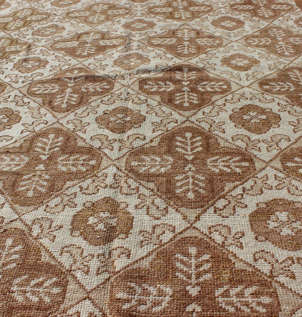 Misure: 4'4 x 7'7.

Questo tappeto Oushak (circa metà del XX secolo) presenta un motivo all-over di fiori e palmette interconnessi e disposti verticalmente. I colori includono varie tonalità di marrone su uno sfondo color crema.

Paese di origine: