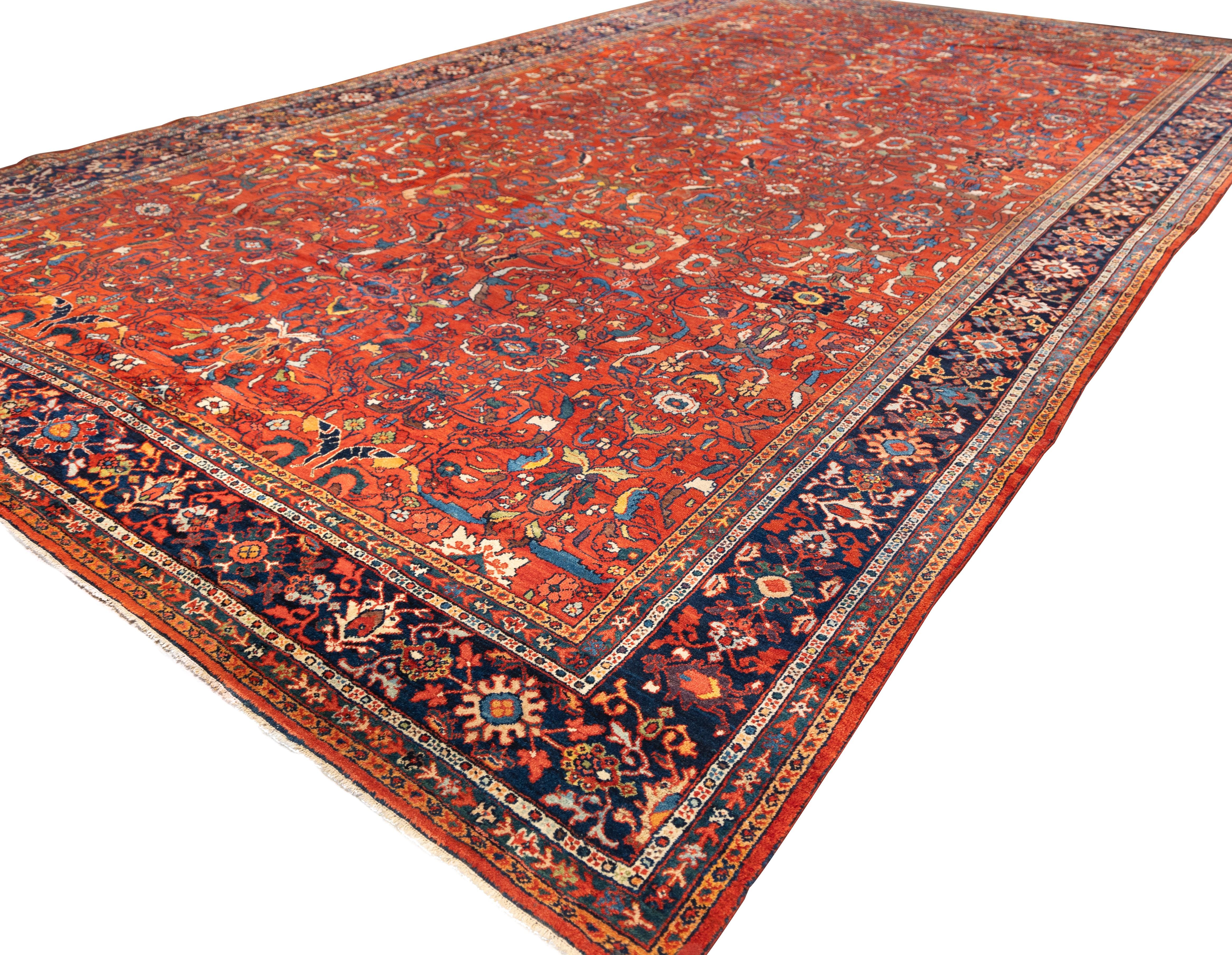 Large Sultanabad featuring an allover lattice of palmettes and floral sprays on a saturated red field. The design is densely packed with large rosettes, angular vines, and curling saz leaves, rendered in navy, ivory, green, and gold tones. The