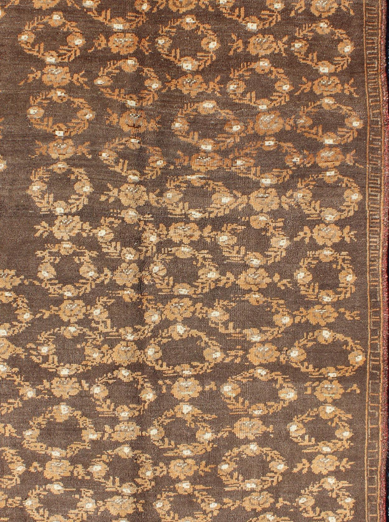 Misure: 4'5 x 7'4

Il design di questo bellissimo tappeto vintage Oushak della Turchia della metà del XX secolo è esaltato dalla sua lana lucente. Il fondo marrone ospita un disegno di ghirlanda marrone decorato con ghirlanda e fiori. Un bordo di