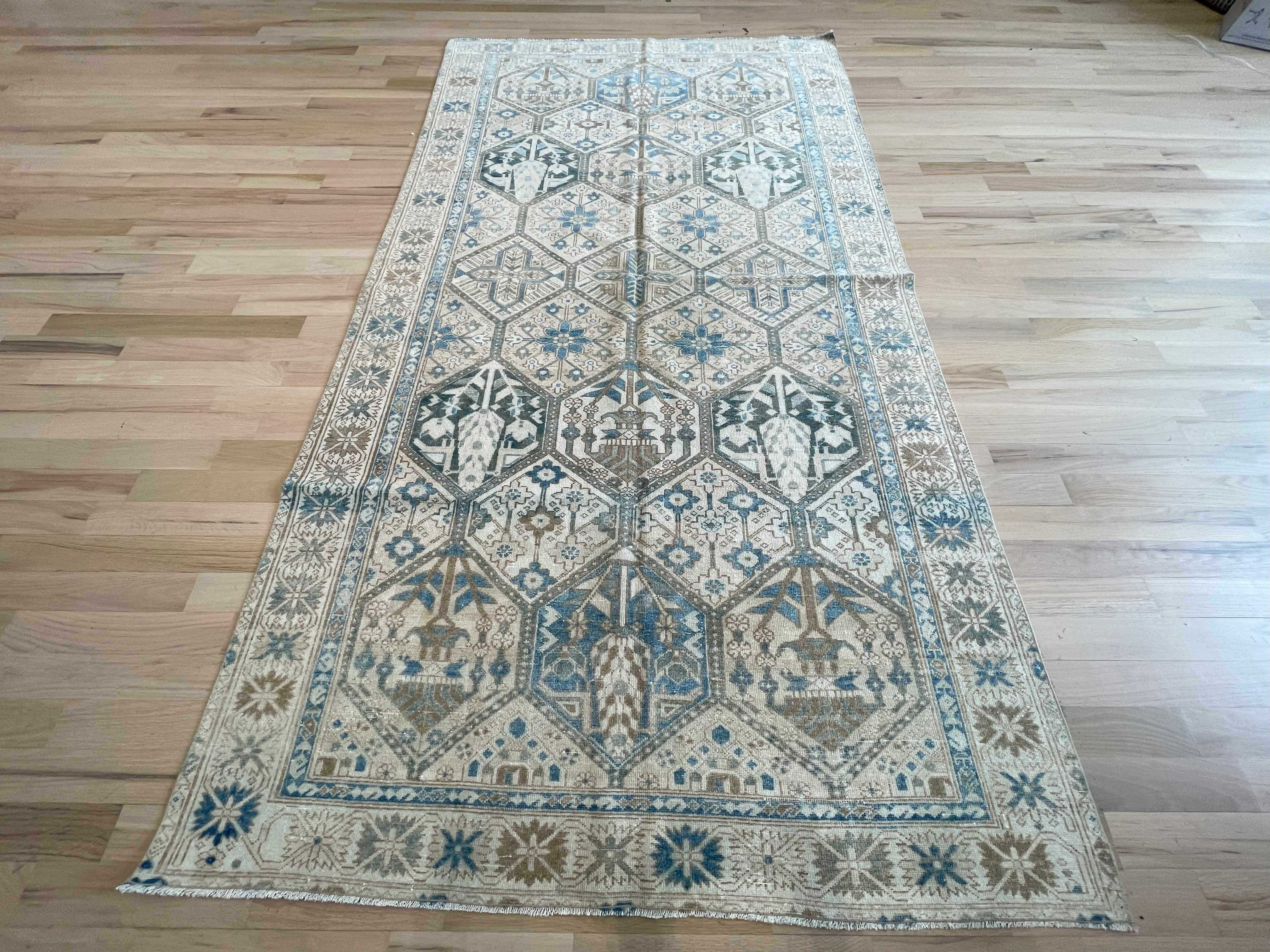 Ce tapis bleu, beige et taupe Semi-Antique Persian Bakhtiari est sûr de rehausser votre espace.  Le motif géométrique est orné de détails complexes représentant des fleurs et des arbres symboliques de la région. Entièrement en laine, teintures