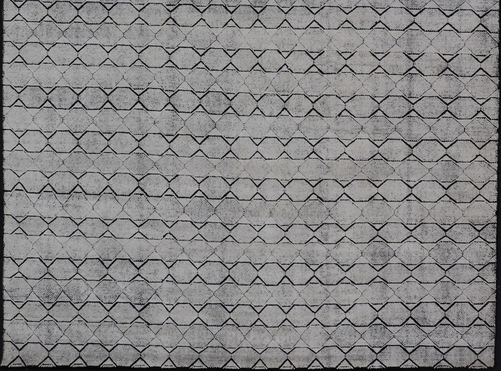 Measures 9'0 x 12'0 

This modern rug features a field of a ivory with a simple geometric design lined by black. The design is a minimalistic, repeating pattern of octagons and triangles paneling the entire face horizontally. With a less-is-more