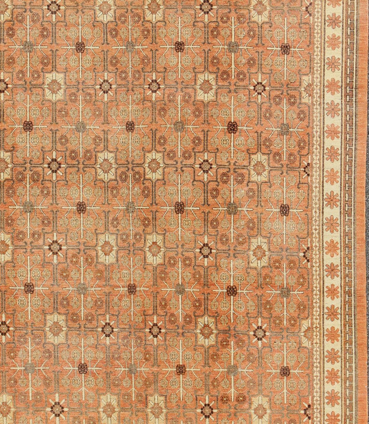 Measures:  9' x 11'9
Khotan design Rug with all over geometric and square Design in light tangerine background with accent colors of charcoal, brown, green and taupe. All-Over Design Khotan Rug in Light Tangerine Background by Keivan Woven Arts /