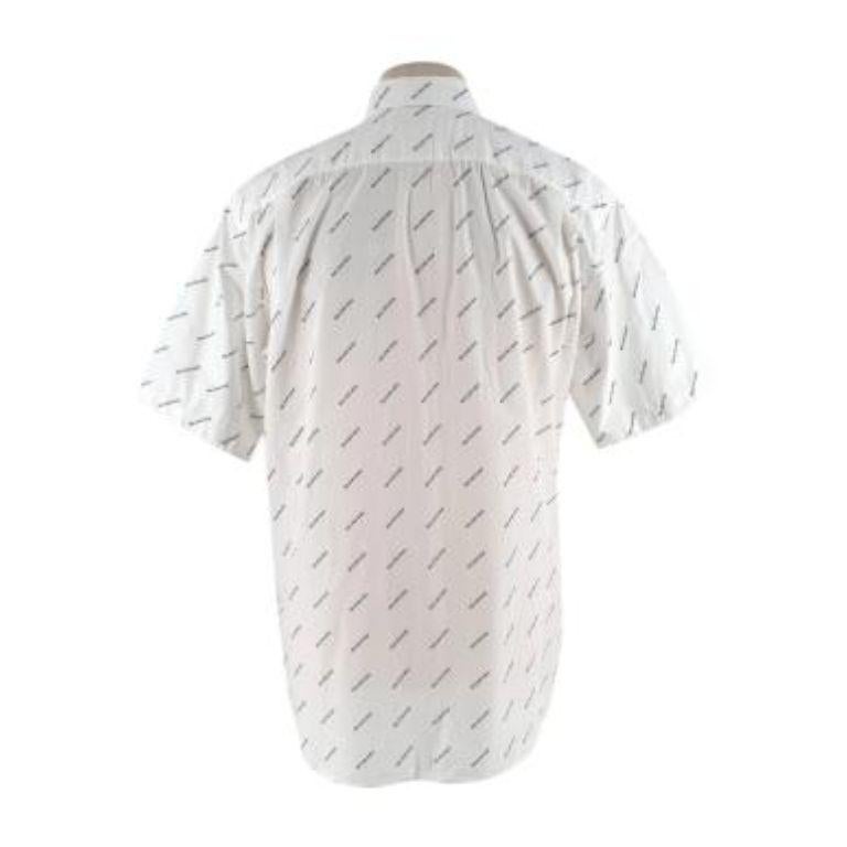 Balenciaga Logo All Over Print Cotton Shirt
 

 -Classic collar
 -Front button fastening
 -Short sleeves
 -Loose fitted 
 

 Material:
 

 100% Cotton 
 

 Made in Italy 
 

 PLEASE NOTE, THESE ITEMS ARE PRE-OWNED AND MAY SHOW SIGNS OF BEING STORED
