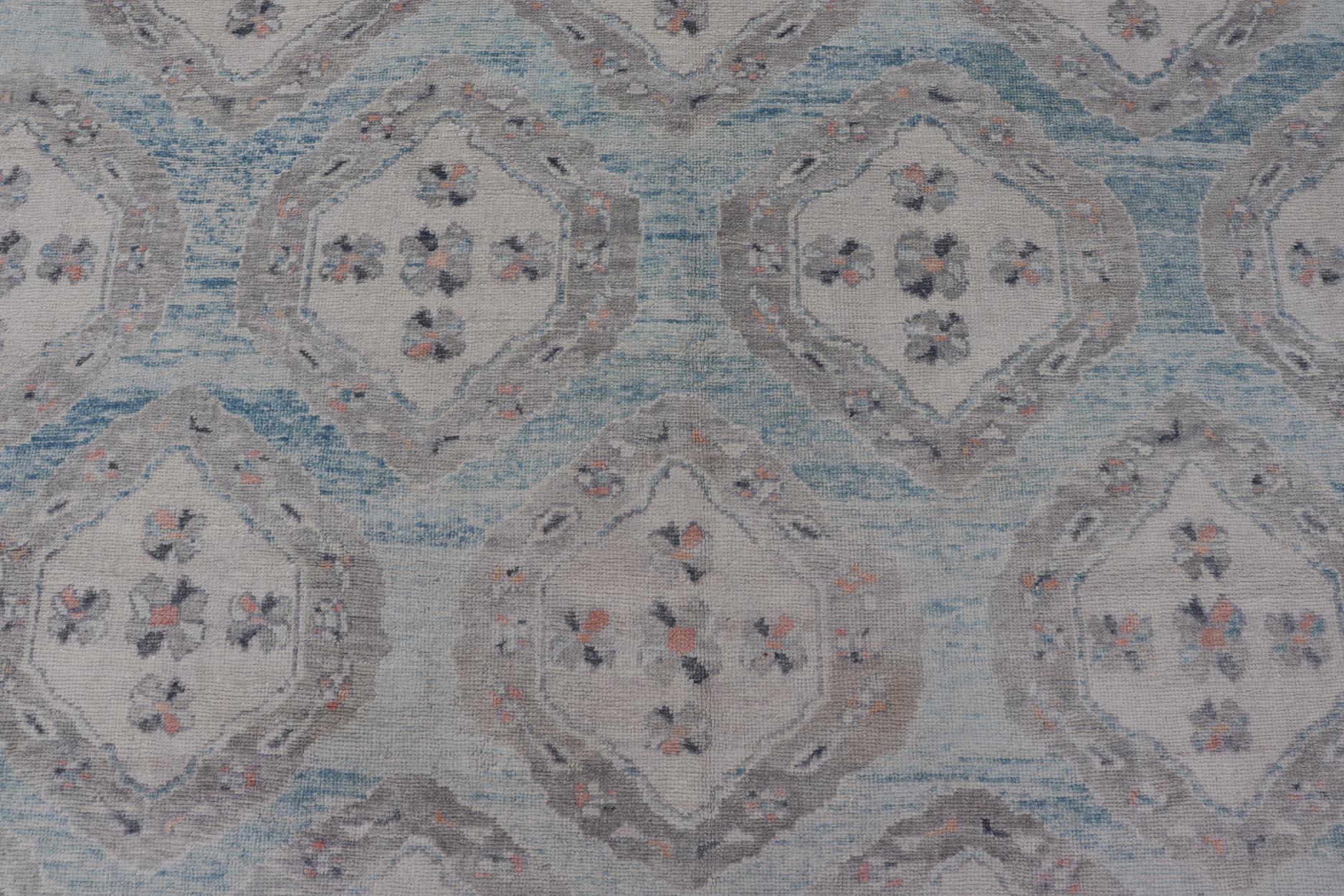Alfombra Oushak Turca con Motivos Tribales en Azul Claro y Toques Naranjas Turco en venta