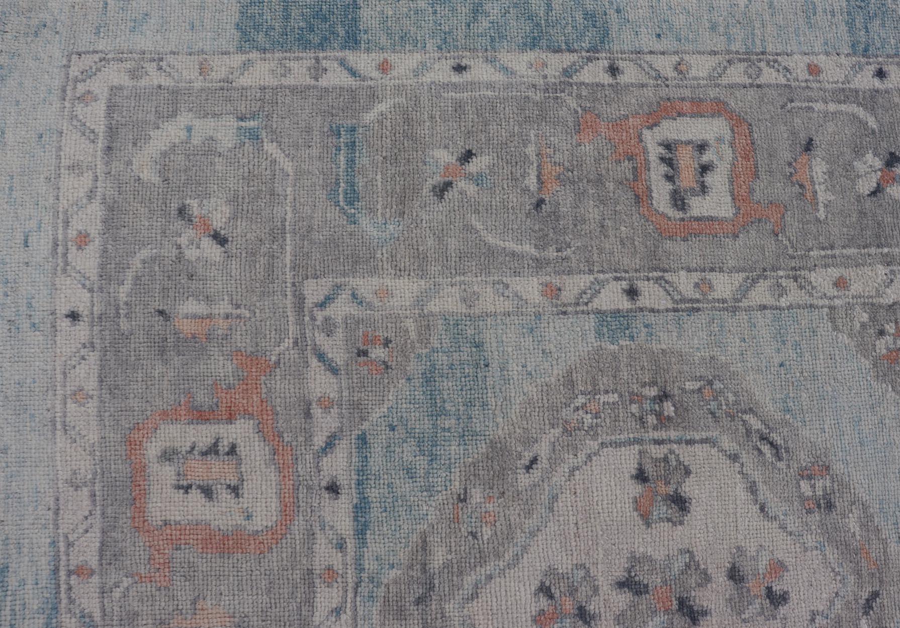 Alfombra Oushak Turca con Motivos Tribales en Azul Claro y Toques Naranjas en Nuevo estado para la venta en Atlanta, GA