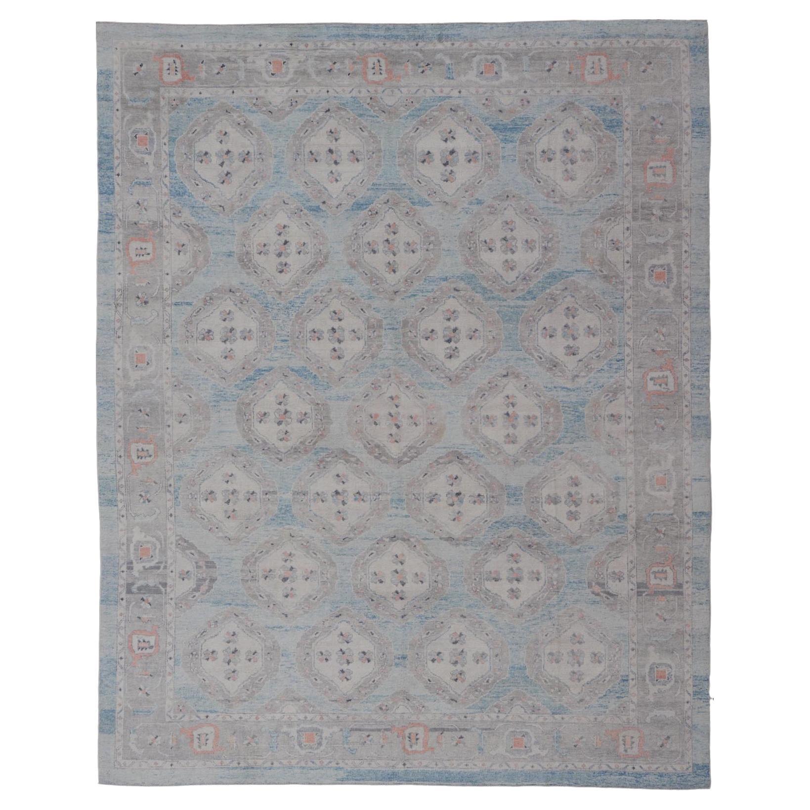 Alfombra Oushak Turca con Motivos Tribales en Azul Claro y Toques Naranjas en venta
