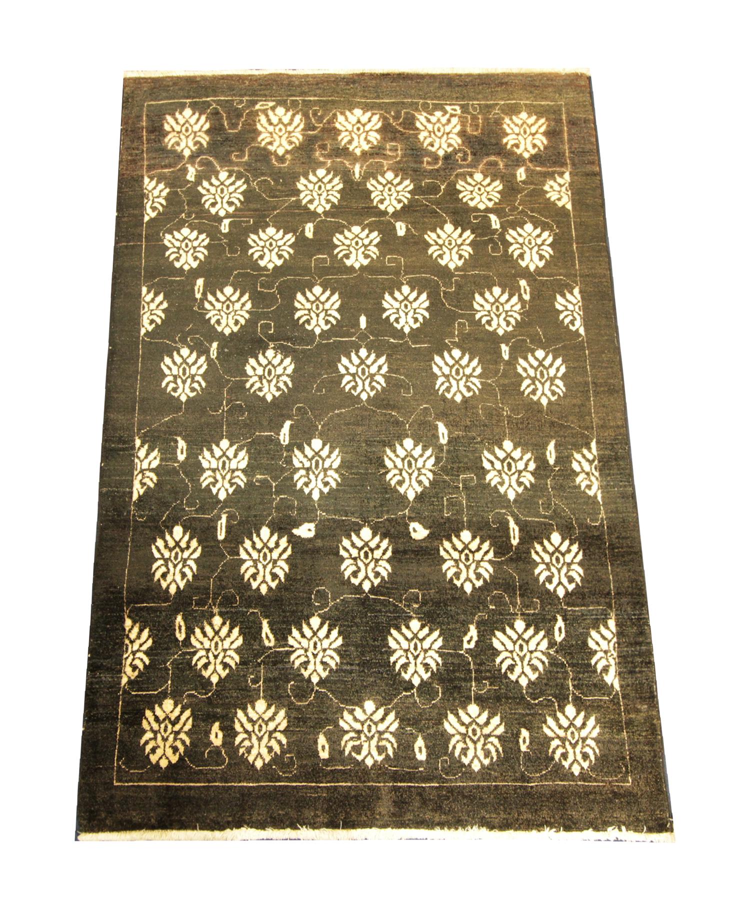 This fine wool Turkish rug was woven with the finest organic materials. The central design has been woven on a black background with an all-over floral pattern with a simple linear border woven in cream. The elegant design and sophisticated colour