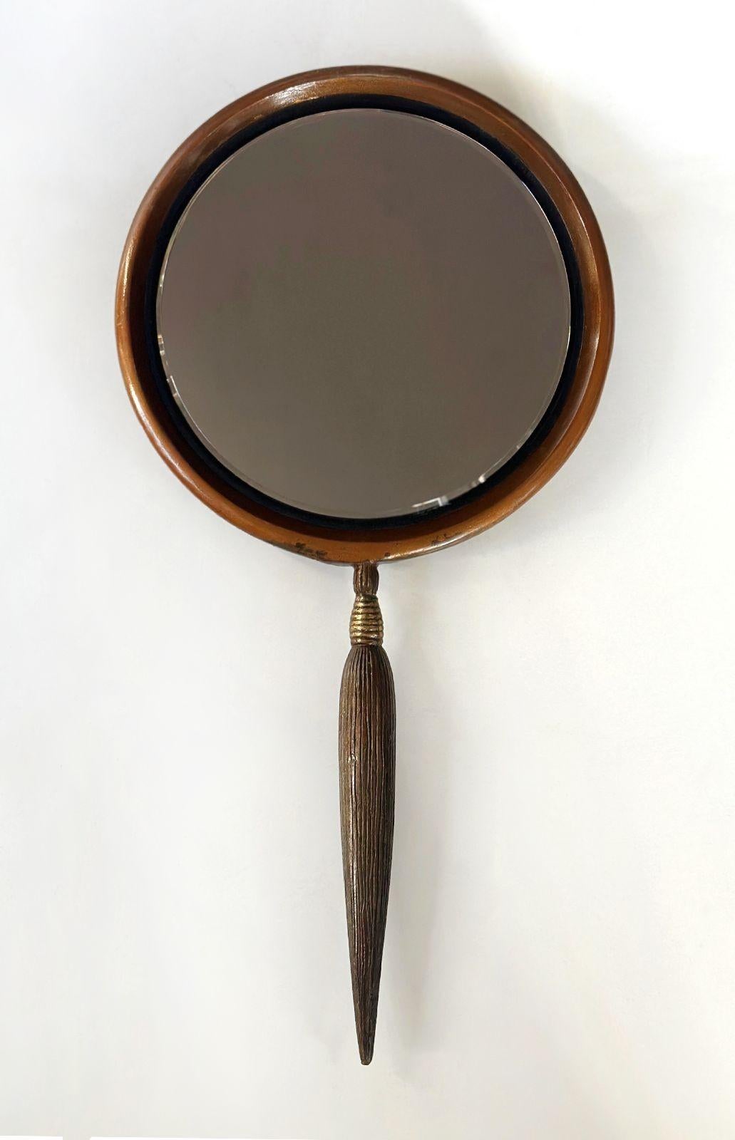 Original limited edition cold painted bronze hand mirror by Erté (Romain de Tirtoff). This mirror seamlessly embodies the essence of Erté's distinctive style. On the reverse side of the piece, a vision of 1930's haute couture emerges with a woman
