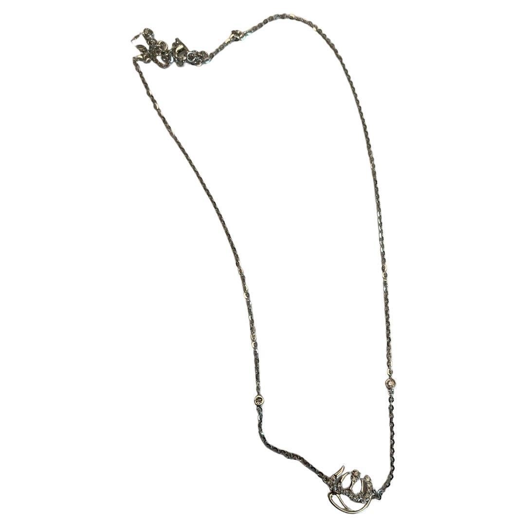 Questa collana con ciondolo è realizzata in un elegante oro bianco 18 carati e con diamanti bianchi di qualità G/VS da 0,18 CTW. La collana presenta una catena delicata ornata da due piccole pietre dal taglio rotondo. Il ciondolo presenta un design