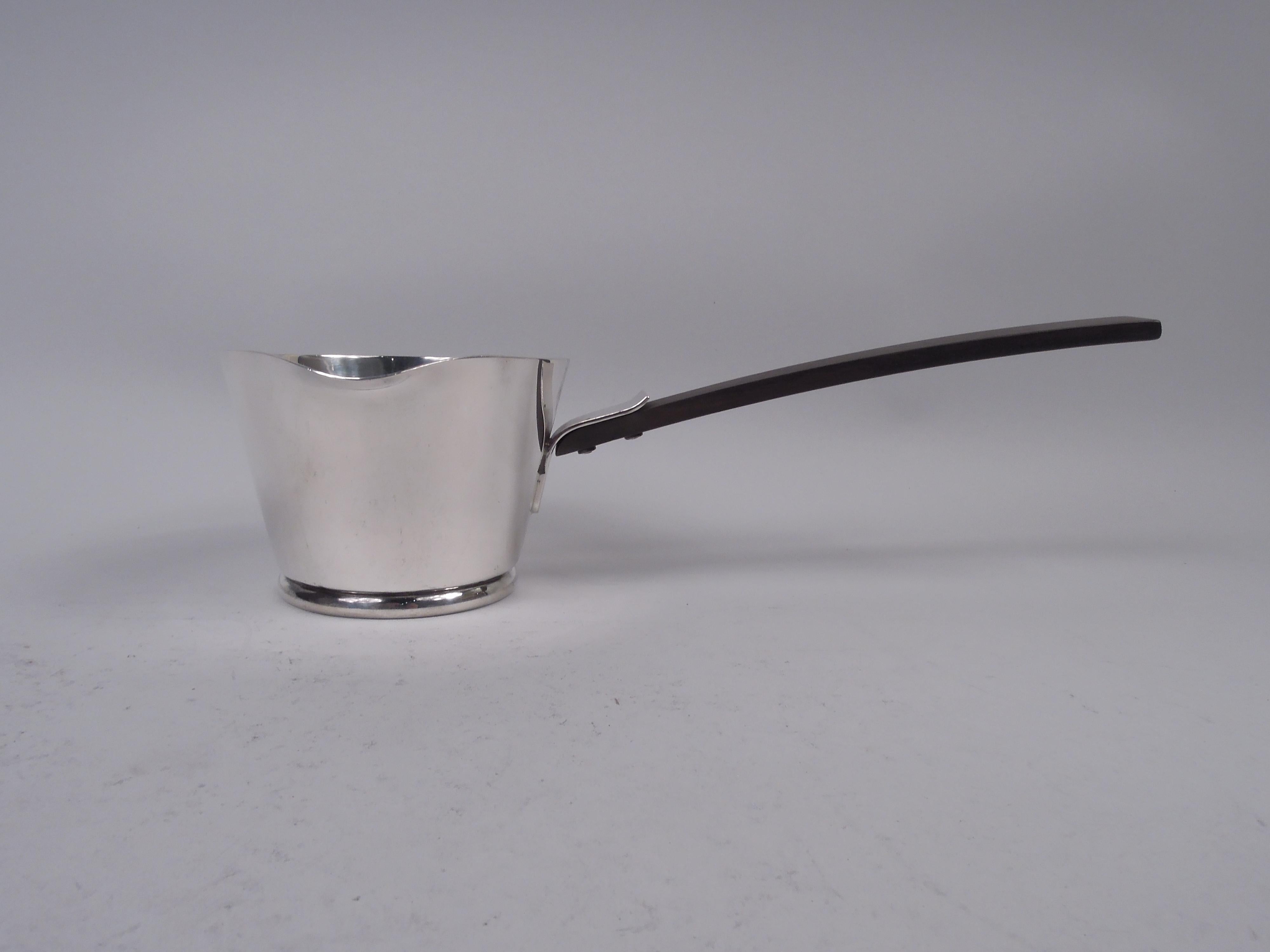 Midcentury Modern sterling silver pipkin. Made by Allan Adler in California. Round and tapering bowl with soft lip spout and skirted base; tapering rectilinear stained-wood handle mounted with silver bracket. Fully marked including maker’s stamp and