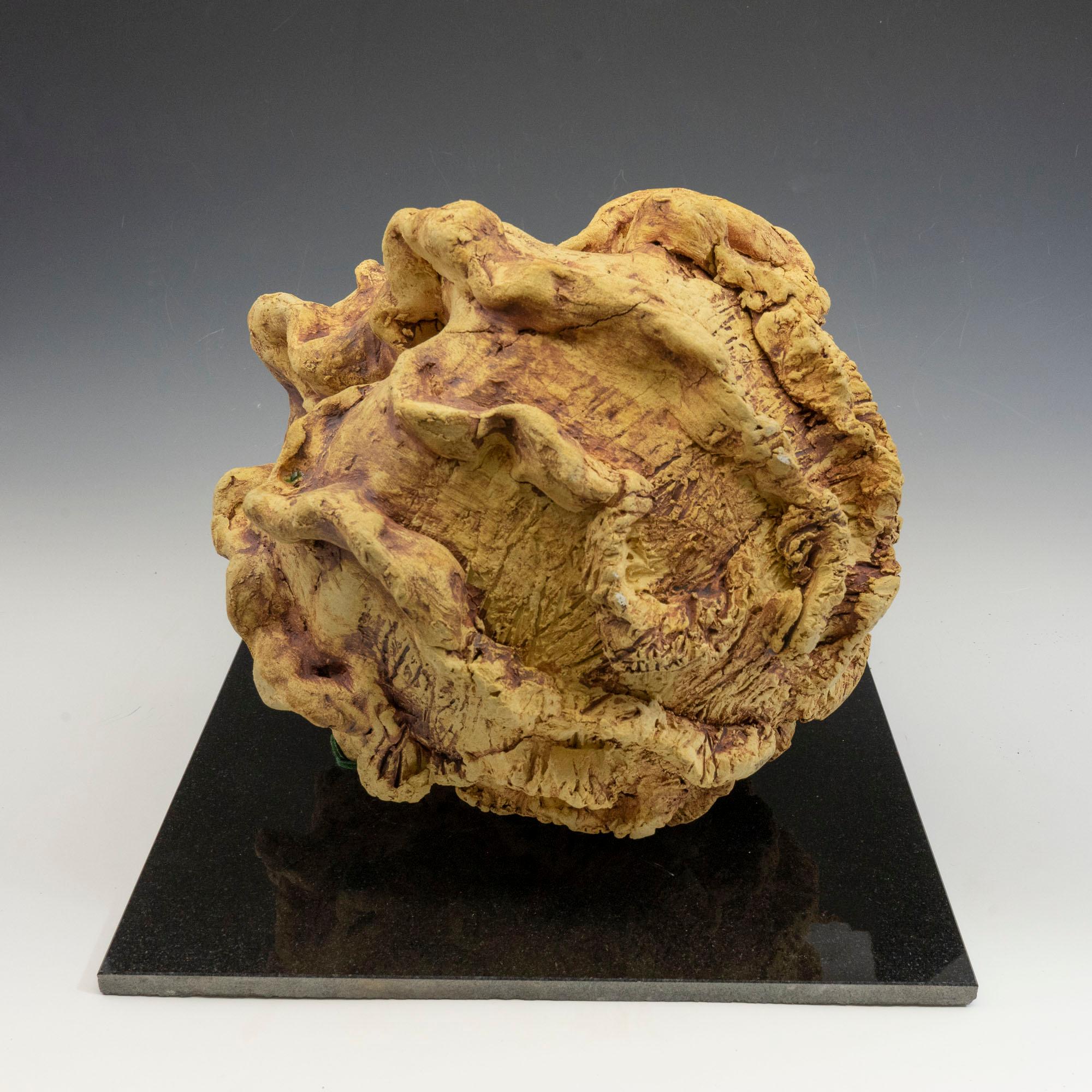 
Hiding Place, golden yellow, textured ceramic, embodies the essence of clay in its organic shapes that refer directly to the earth and nature. The artist says 