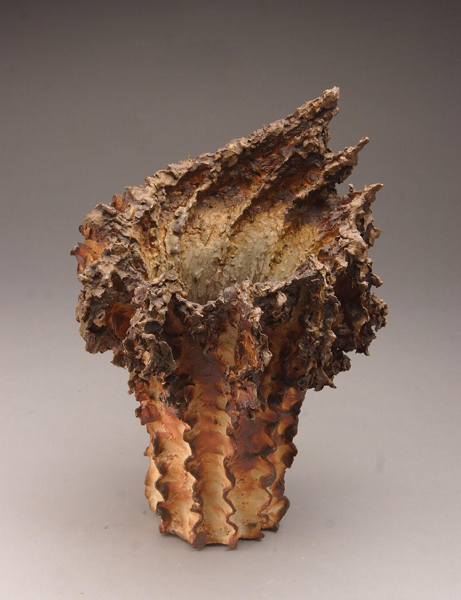 Vase, textured ceramic in golden browns, embodies the essence of clay in its organic shapes that refer directly to the earth and nature. The artist says 