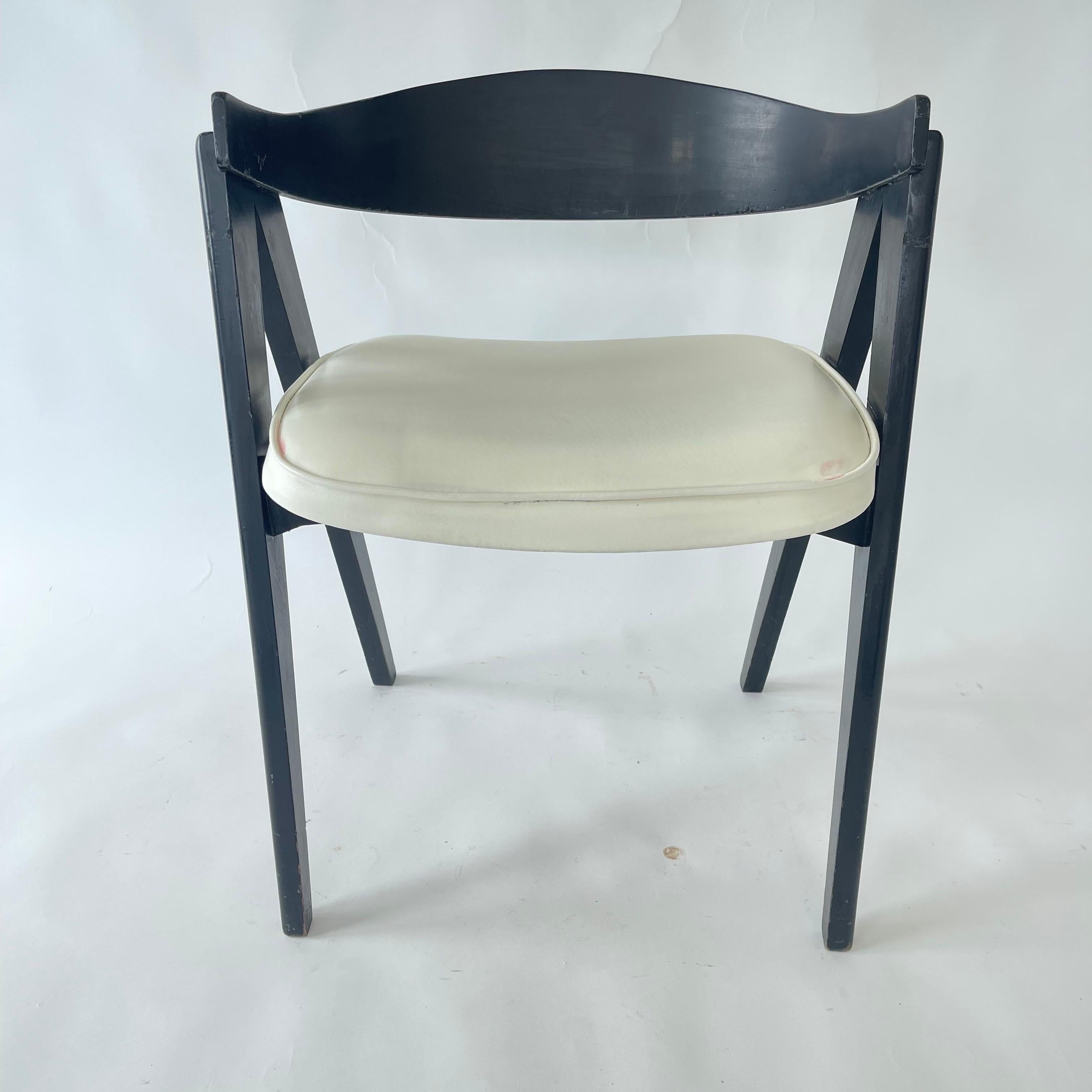 Sculptural American Modern Compass Chair with a unique scooped back, rendered in a black painted wood frame and white vinyl upholstery.  Attributed to Allan Gould for Herman Miller, USA, 1940s