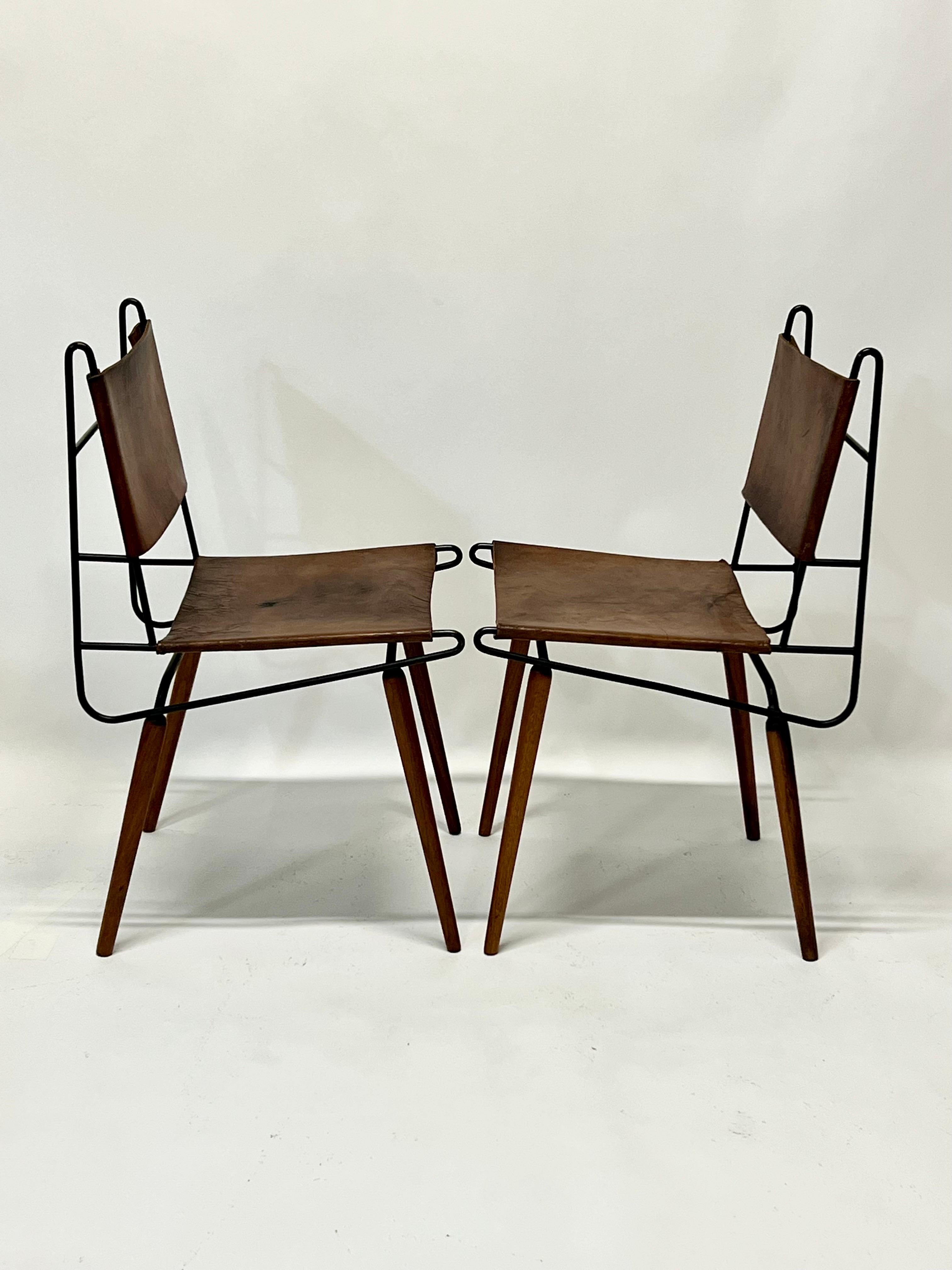 Exceedingly rare iron and leather dining chairs with wooden dowel legs by East Coast designer, Allan Gould, circa 1950s. Gould who is more known for his amazing iron string chairs, this model predates those. Only made in very small numbers, and for