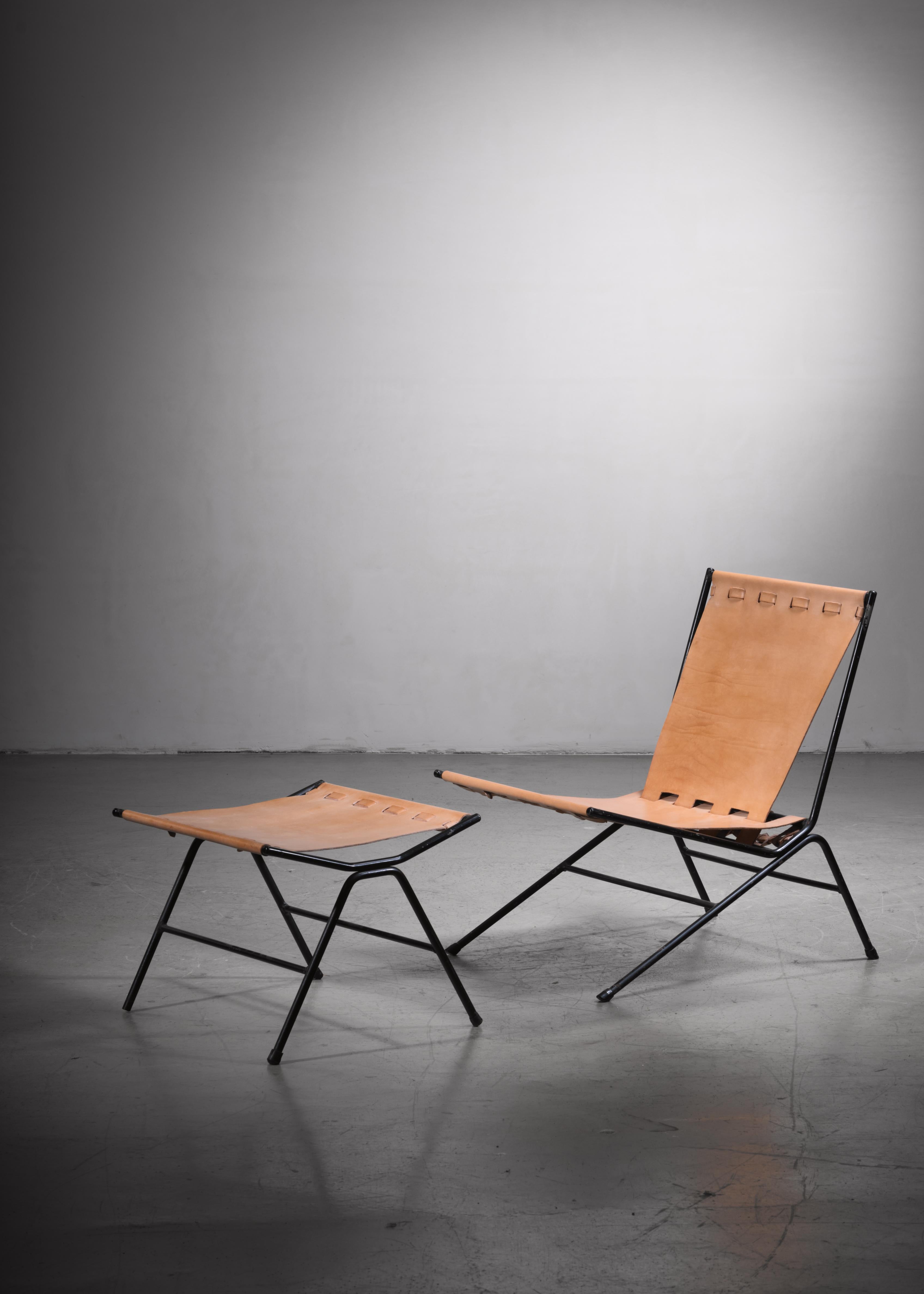 An Allan Gould 'bow'' lounge chair with a matching ottoman. The pieces are made of a black iron frame with a natural leather sling seating. They are professionally reupholstered in our in-house atelier.

The measurements stated are of the chair.