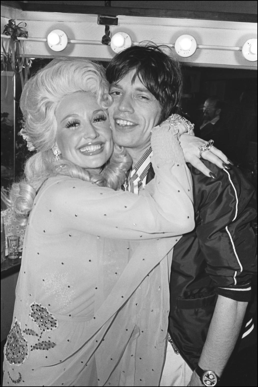 Allan Tannenbaum Black and White Photograph - Dolly Parton and Mick Jagger hugging