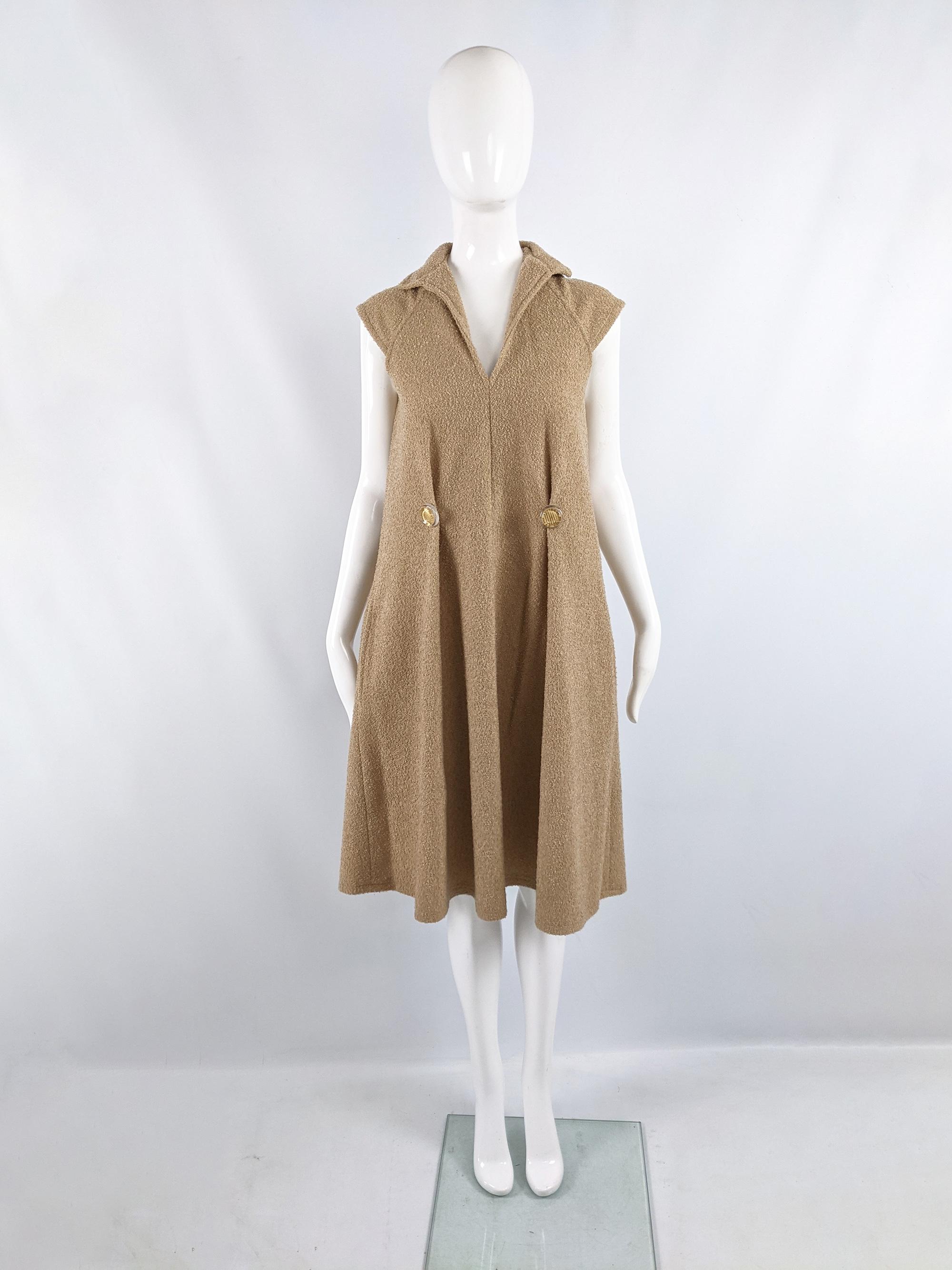 A chic vintage womens dress from the 70s by British label, Allander. In a tan bouclé fabric with cap sleeves and an incredible loose tent / a line shape and cap sleeves that give a minimalist look. It has statement, decorative acrylic buttons at the