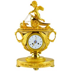 Horloge urne allégorique de l'Empire français représentant Cupidon sur un dessin de chariot par Doves