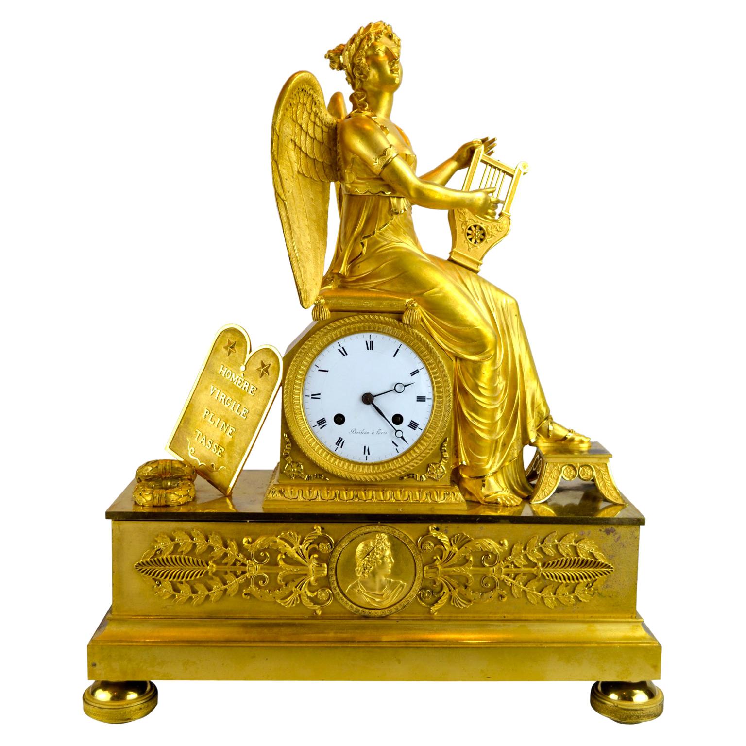 An Allegorical gilt bronze French Empire clock Depiction Clio, the the Greek Muse of History and Music. Clio is shown here sitting on the clock plinth playing her harp. To the left of the clock dial are placed wreaths, and a plaque with the names of