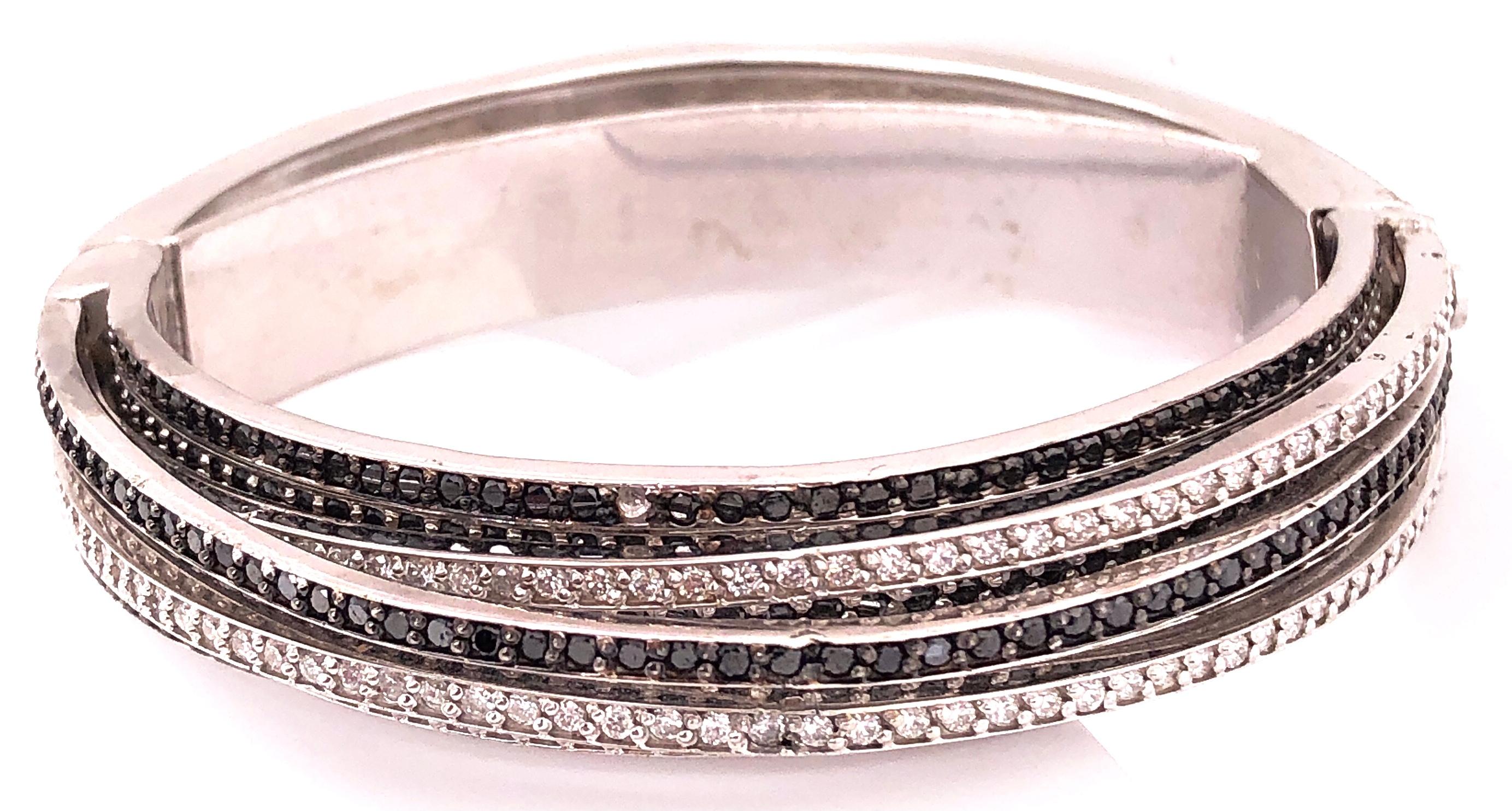 14 Karat After Allegra de Grisogono White Gold Eight-Row Mix Tiered White and Colored Enhanced Black Diamond Bangle. Patent No. 4697315 85 grams total weight. Approx 3 plus Carat Total Diamond Weight. Unsigned. Matching Ring and Earrings sold