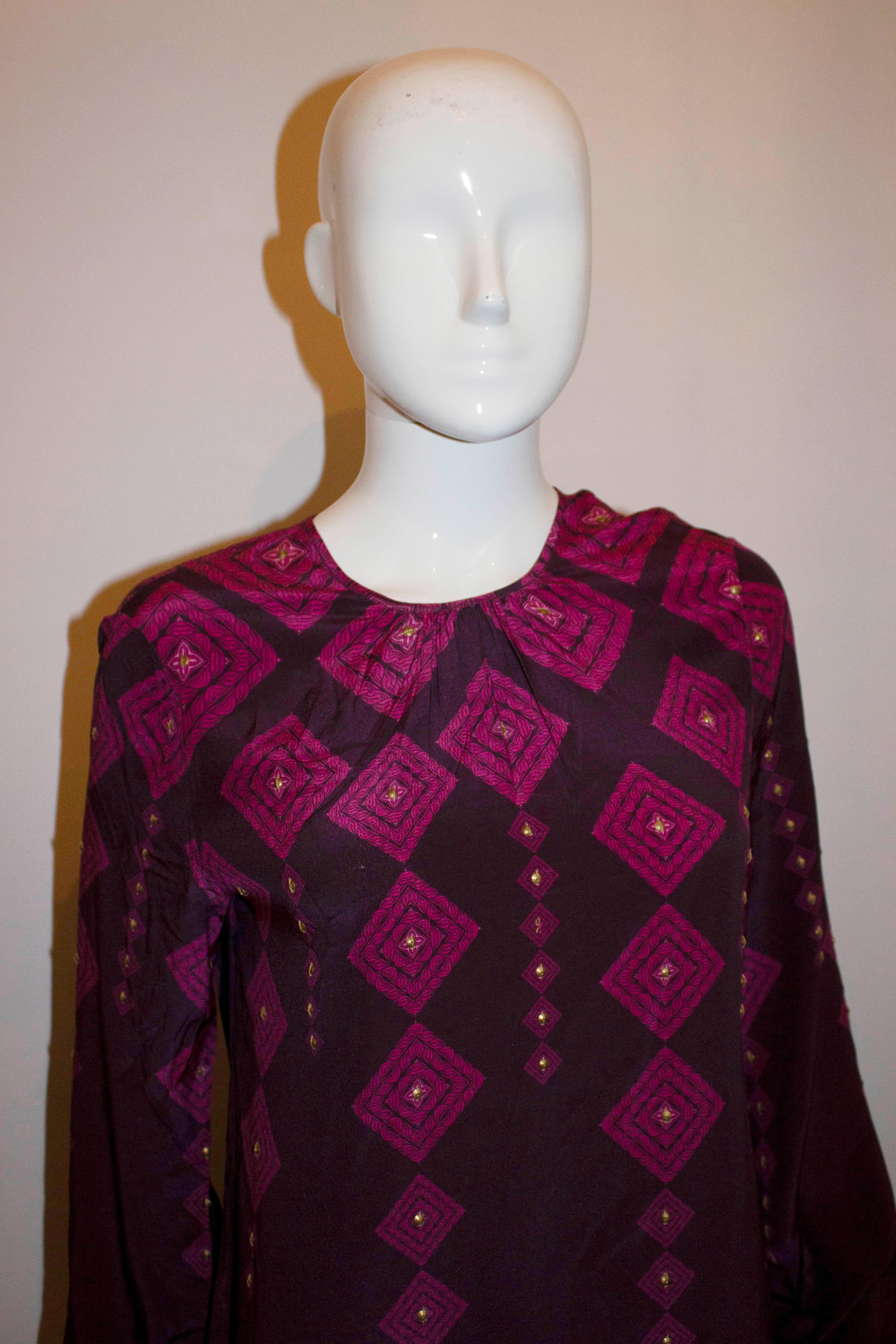 A pretty purple silk dress by Allegra Hicks , Limited range.  The dress is in a purple and pink silk with gold button detail, and button opening at the neck. Made in Italy, UK size 10. Bust 37'', length 40''