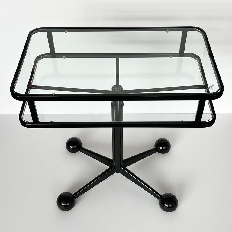Modern rolling two tier bar cart by Allegri Arredamenti, Parma Italy circa 1970s. Black enameled steel frame inset with two glass surfaces. Four rolling recessed casters in stylized modernist base / legs. Adjustable in height. 4 3/8