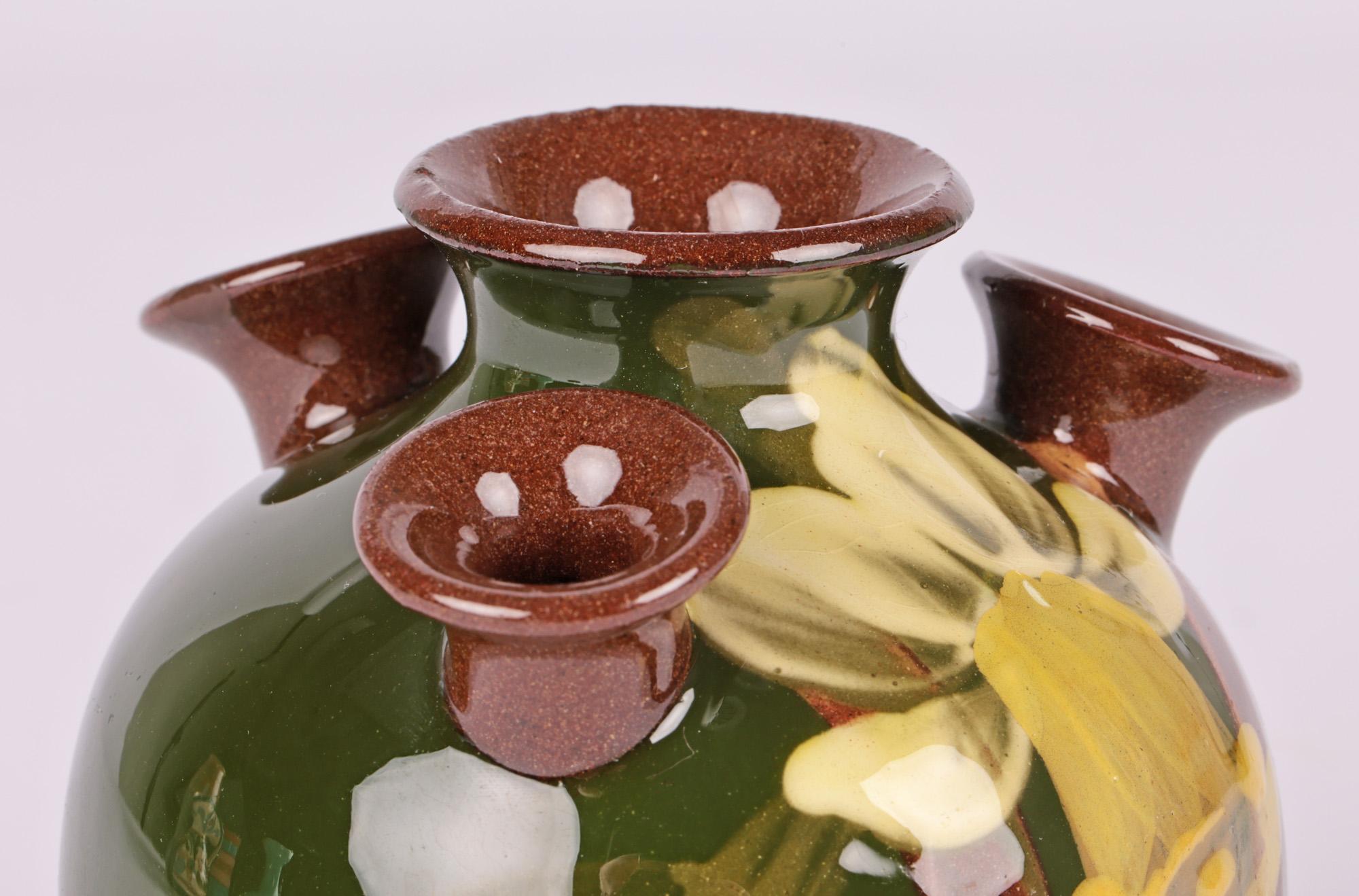 Uno scarso vaso a più colli (mammelle) in ceramica di Torquay Devon, dipinto a mano con un narciso, attribuito alla Aller Vale Pottery e risalente al 1890 circa. Il vaso in terracotta ha una forma rotonda e bulbosa che poggia su una base piatta e