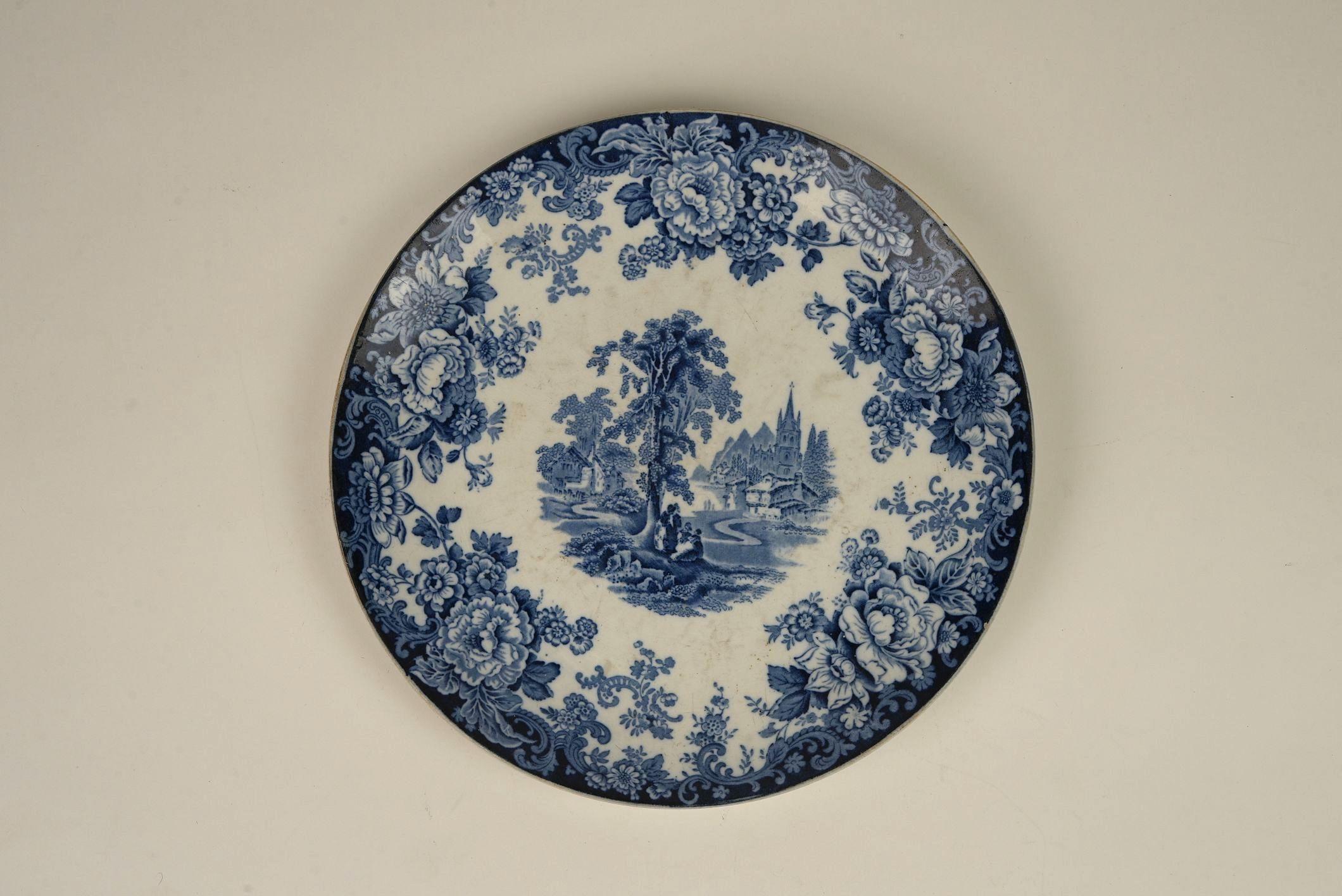 This exquisite blue and white plate by Allertons Ltd., a renowned English pottery established in 1831, is a stunning example of classic transferware craftsmanship. Titled 