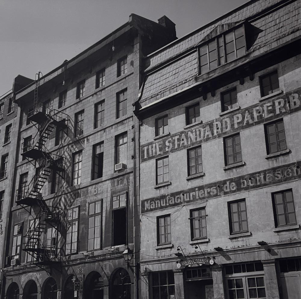 Alli Wood Black and White Photograph – Les Deux Pierrots (Gebäude im alten Gebäude in Quebec City, Kanada)
