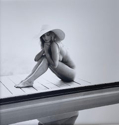 Reflet, femme nue avec chapeau au bord d'une piscine
