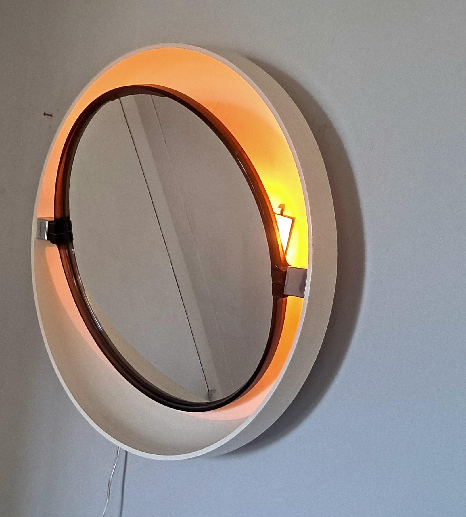 Vintage German back-lit mirror. The back is made of plastic, the mirror is pivoting There is a cord on the side for switching the light on and off.
 
