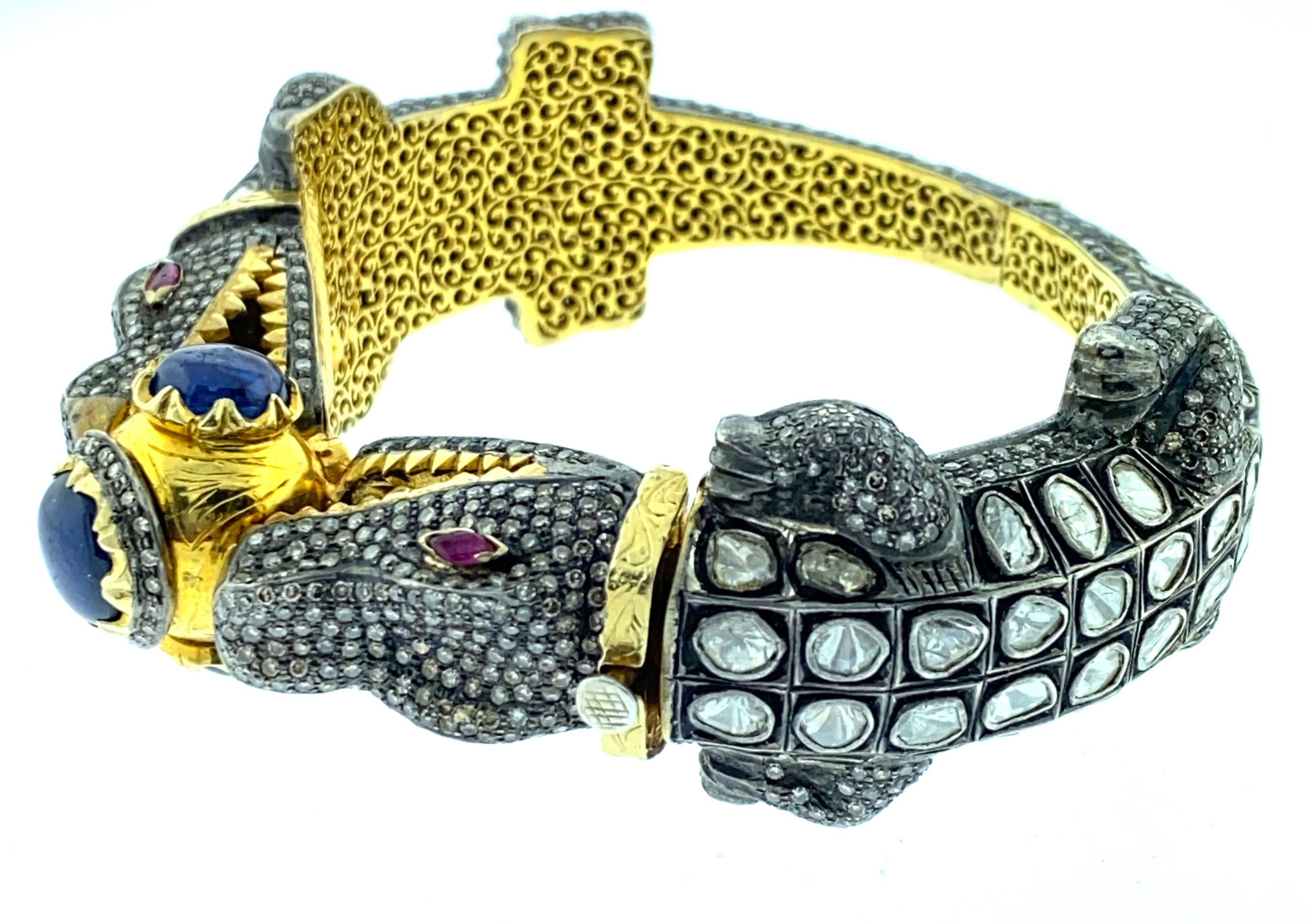 Alligator Polki 13.99ct Diamond 9.24 ct Sapphire Bangle set in Oxidized Sterling Silver and pure 14K Gold. The inside of the bangle is pure 14K Gold which is finely crafted and carved by hand. The saftey of the bangle is a secure 14K Gold safety.