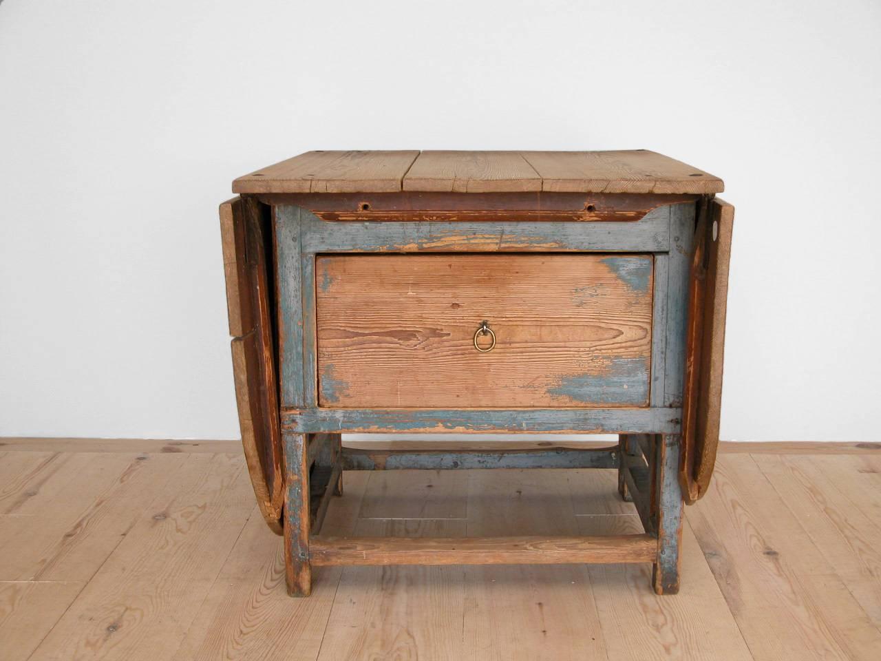 An exceptional Swedish, Allmoge drop-leaf farm table with center drawer, circa 1820, origin: Northern Sweden. All original blue paint with a beautiful patina.  The purity of the design, still modern almost Judd-like in its form, are quintessential