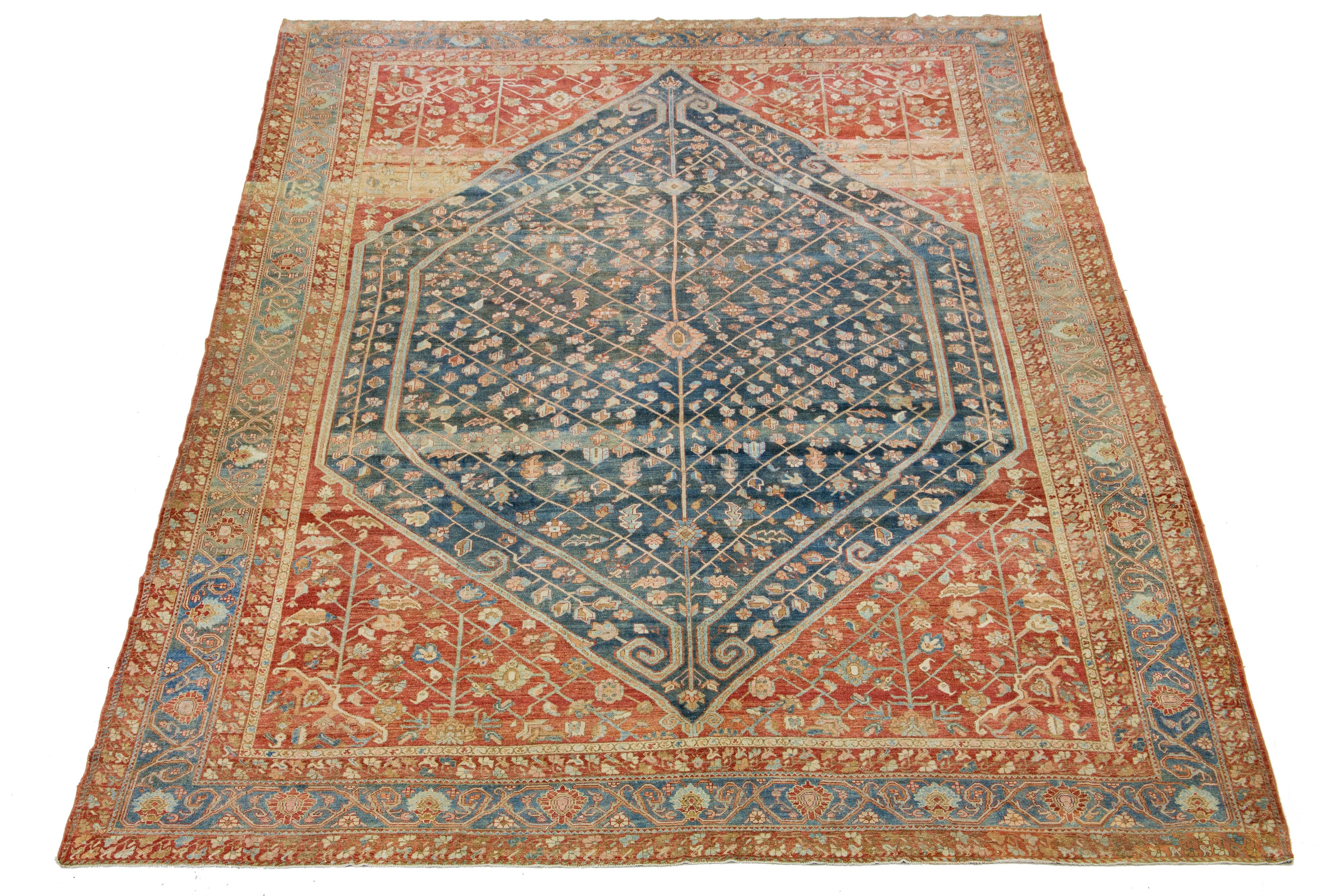 Beautiful Antique Bakhtiari hand-knotted wool rug with a blue color field. This Persian piece has a classic geometric floral design in red-rust and peach colors.

This rug measures 14'9