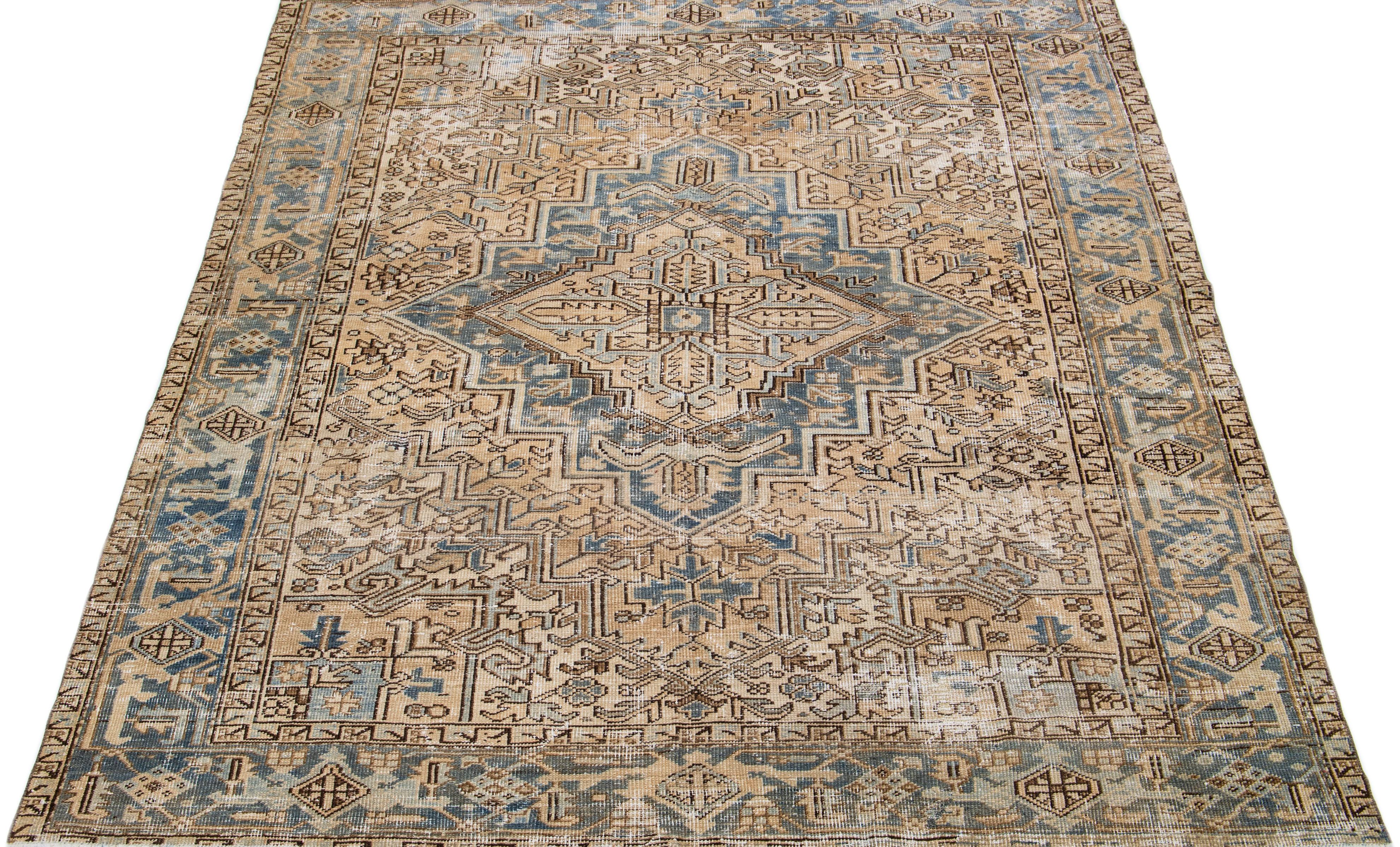 Beautiful antique Heriz hand-knotted wool rug with a beige field. This Persian rug has blue and brown accents in a gorgeous all-over layout medallion floral design.

This rug measures: 7' x 8'5
