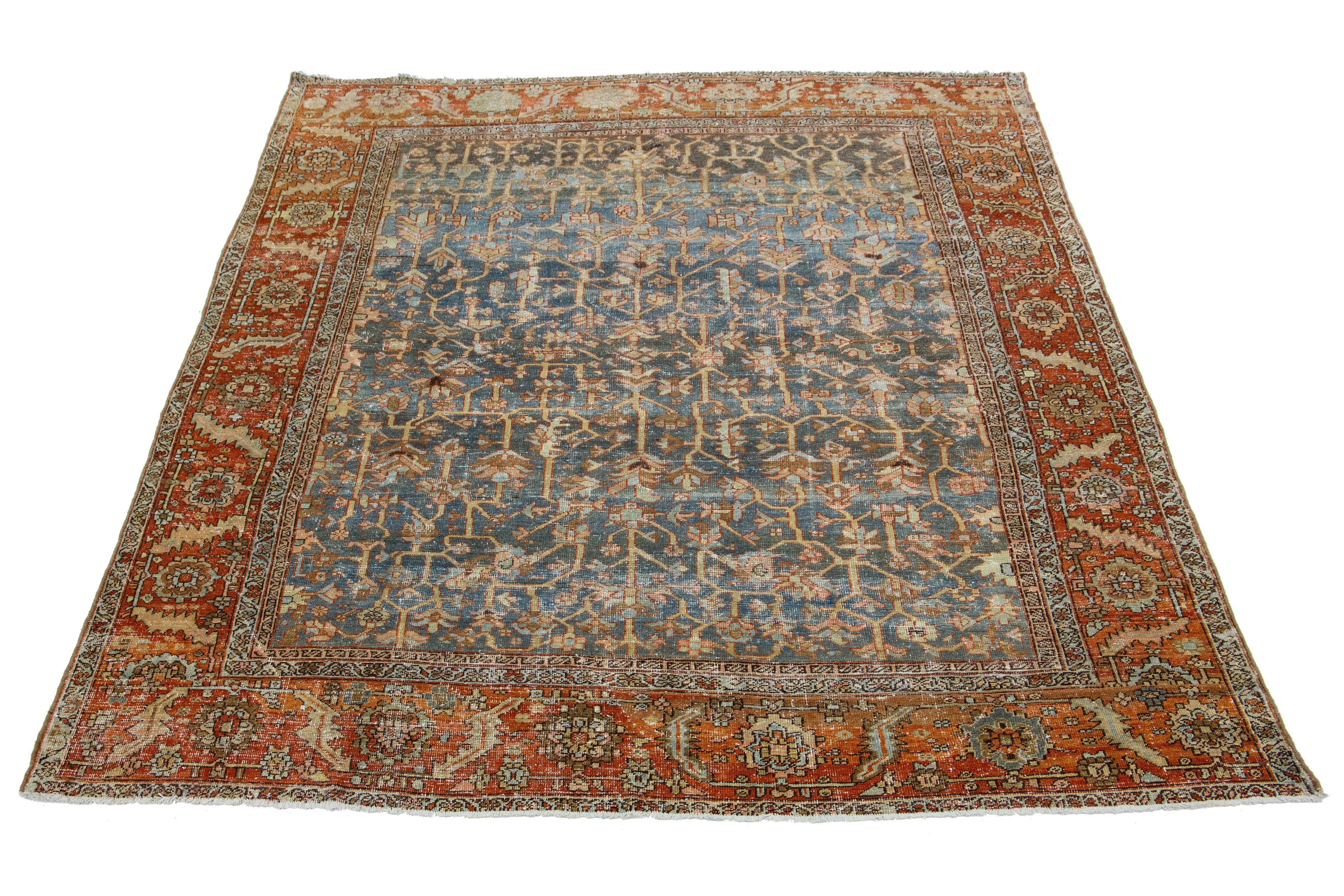 This antique Persian Heriz rug is made with hand-knotted wool. The blue field showcases a captivating allover pattern with beige, peach, and rust shades.

This rug measures 9'1
